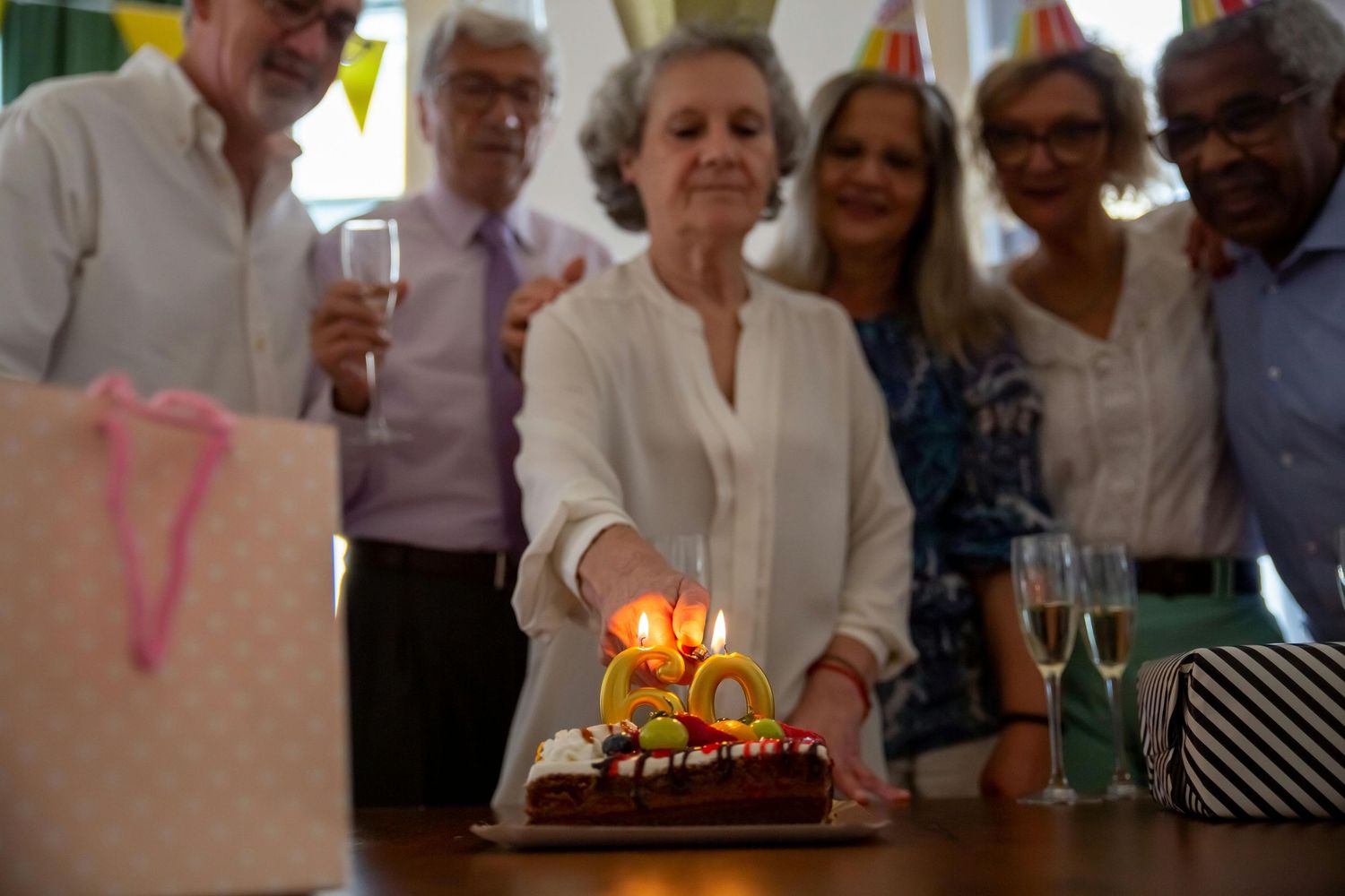 Best Photographer Chandler. A group gathers around a birthday cake with lit candles in a celebratory indoor setting.
