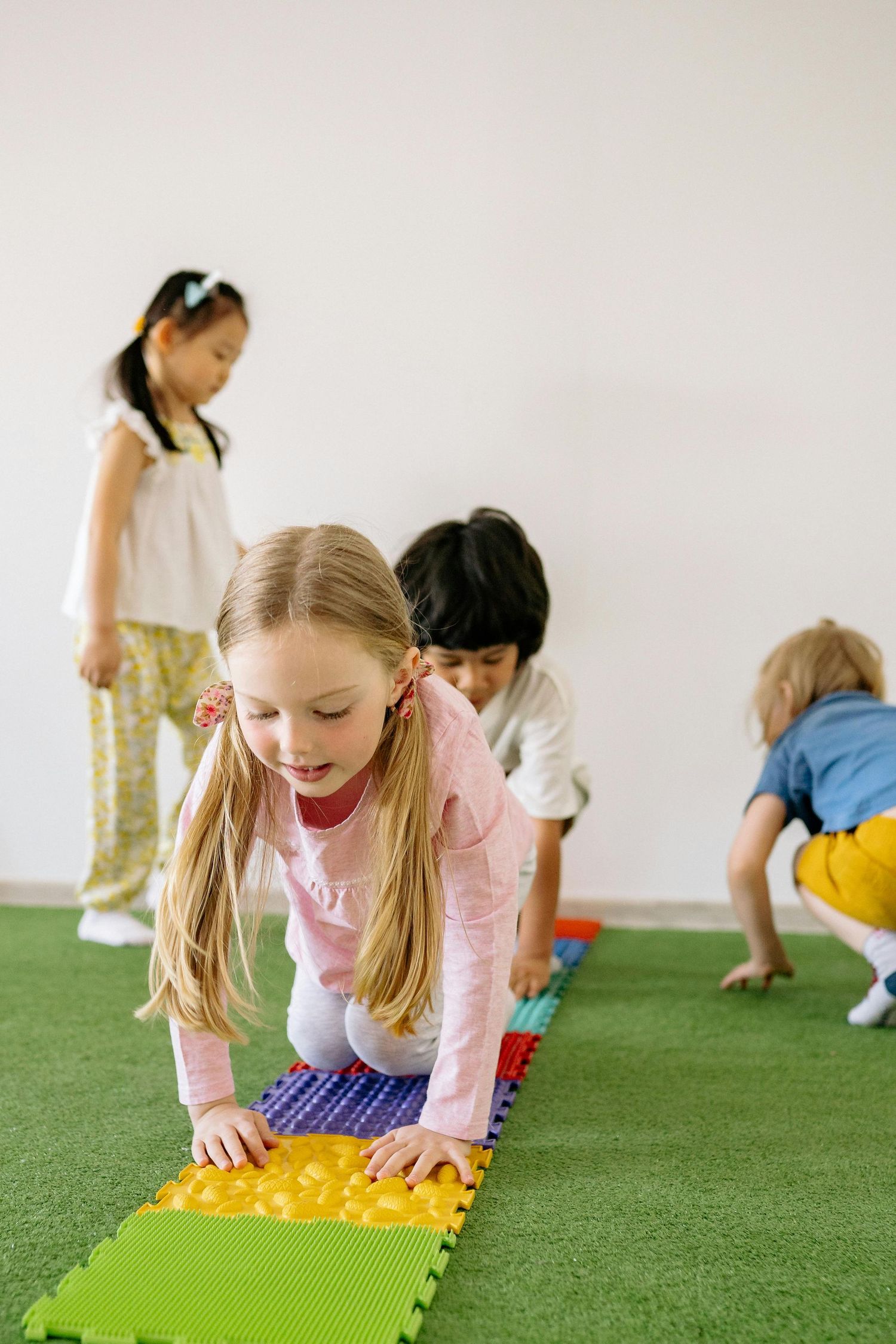 Queen Creek  Arizona Daycare Photography Students participating in interactive learning activities on green floor mats.