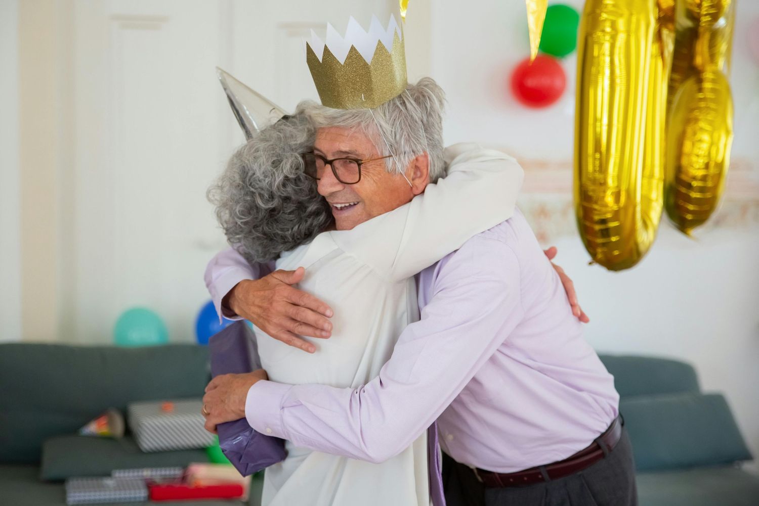 Phoenix Photographer. Celebratory gathering with people embracing under yellow bunting and balloon decorations.