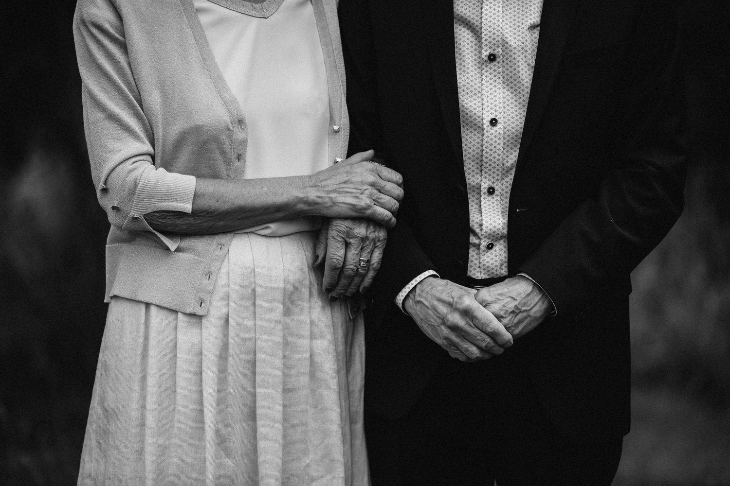 A series of black and white photos showing hands clasped together in formal attire. Senior portraits.