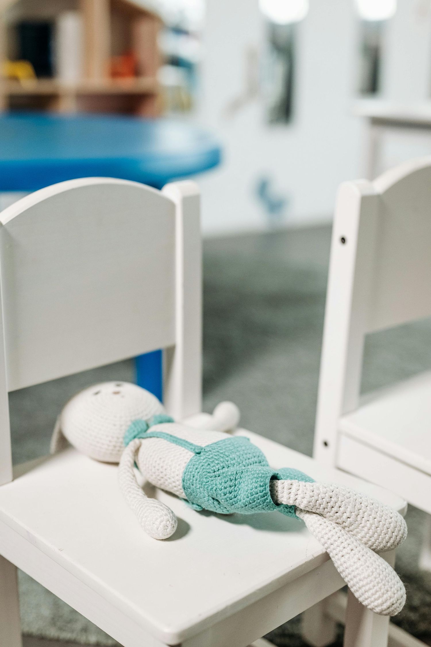 Scottsdale Arizona Photography Close-up view of turquoise and white knitted gloves on white wooden chairs.