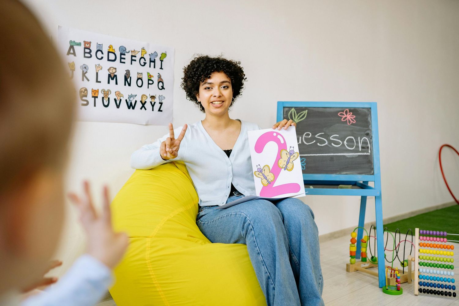 Queen Creek  Arizona Daycare Photography Educational setting with alphabet letters on wall and yellow bean bag seating.