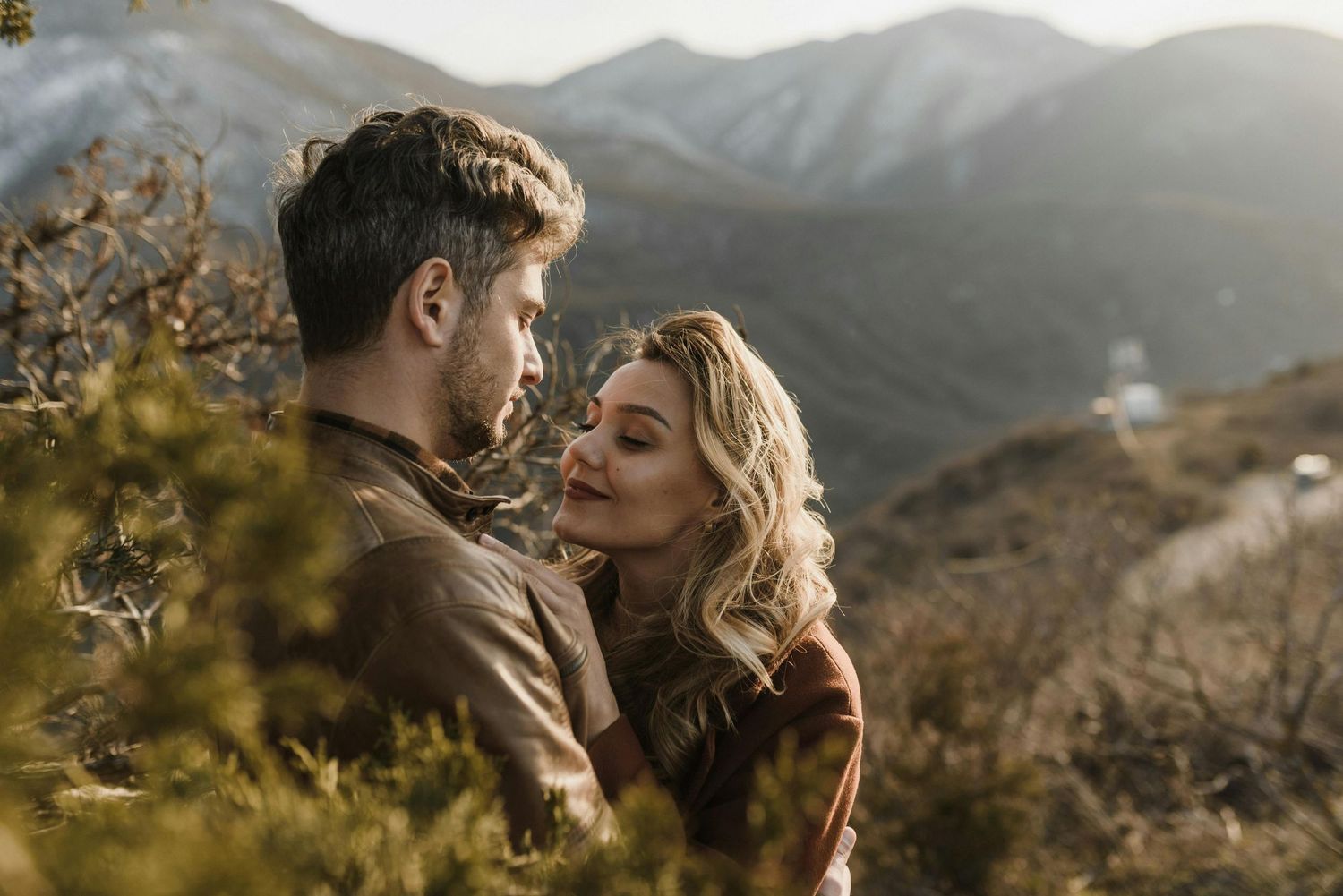 Loving couple atop Prescott peaks, red hat elegance, intimate engagement, shot by finest engagement photographer Arizona.