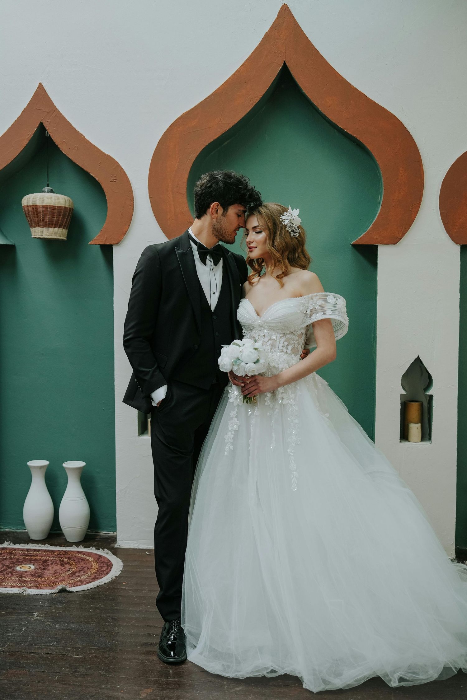 A wedding photo sequence showing a couple posing against a green wall with decorative arched alcoves.  Award Winning Photographer Scottsdale