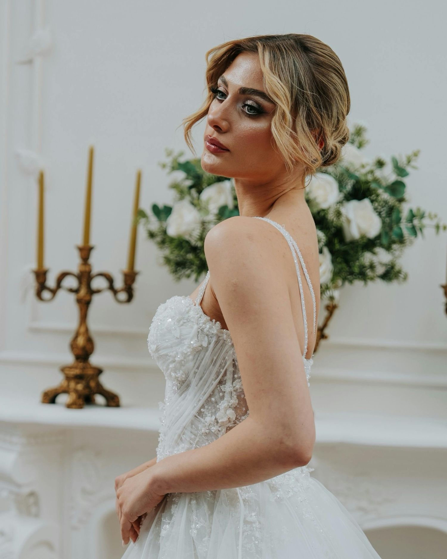 Elegant bridal portraits in a luxurious white room with gold candelabras and floral arrangements.  Award Winning Photographer Scottsdale.