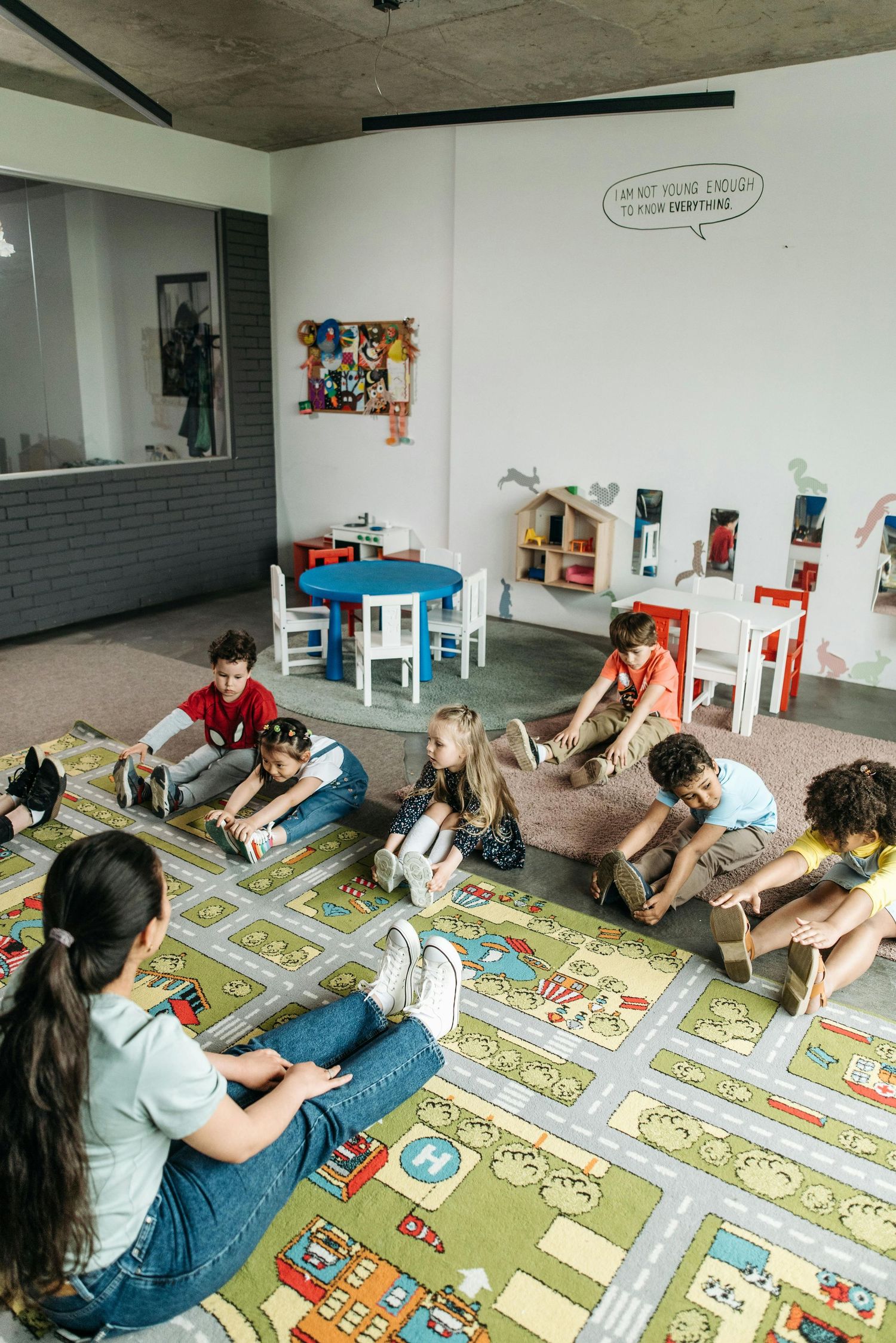 Arizona Daycare Photography Students sitting on colorful play mat during classroom activity.