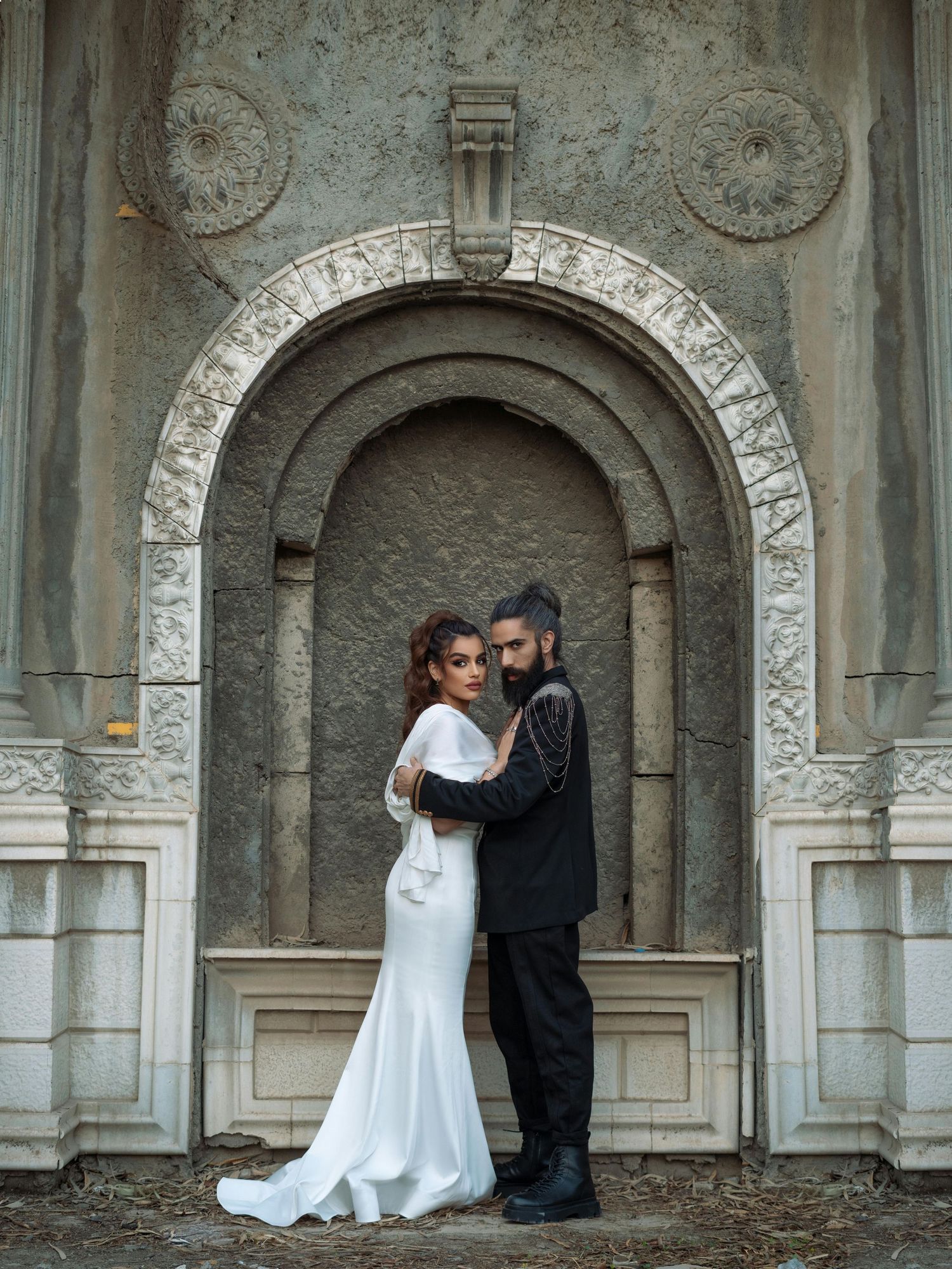 A romantic black and white wedding photo of a couple posing under stone archways. Trusted Flagstaff Photographer.