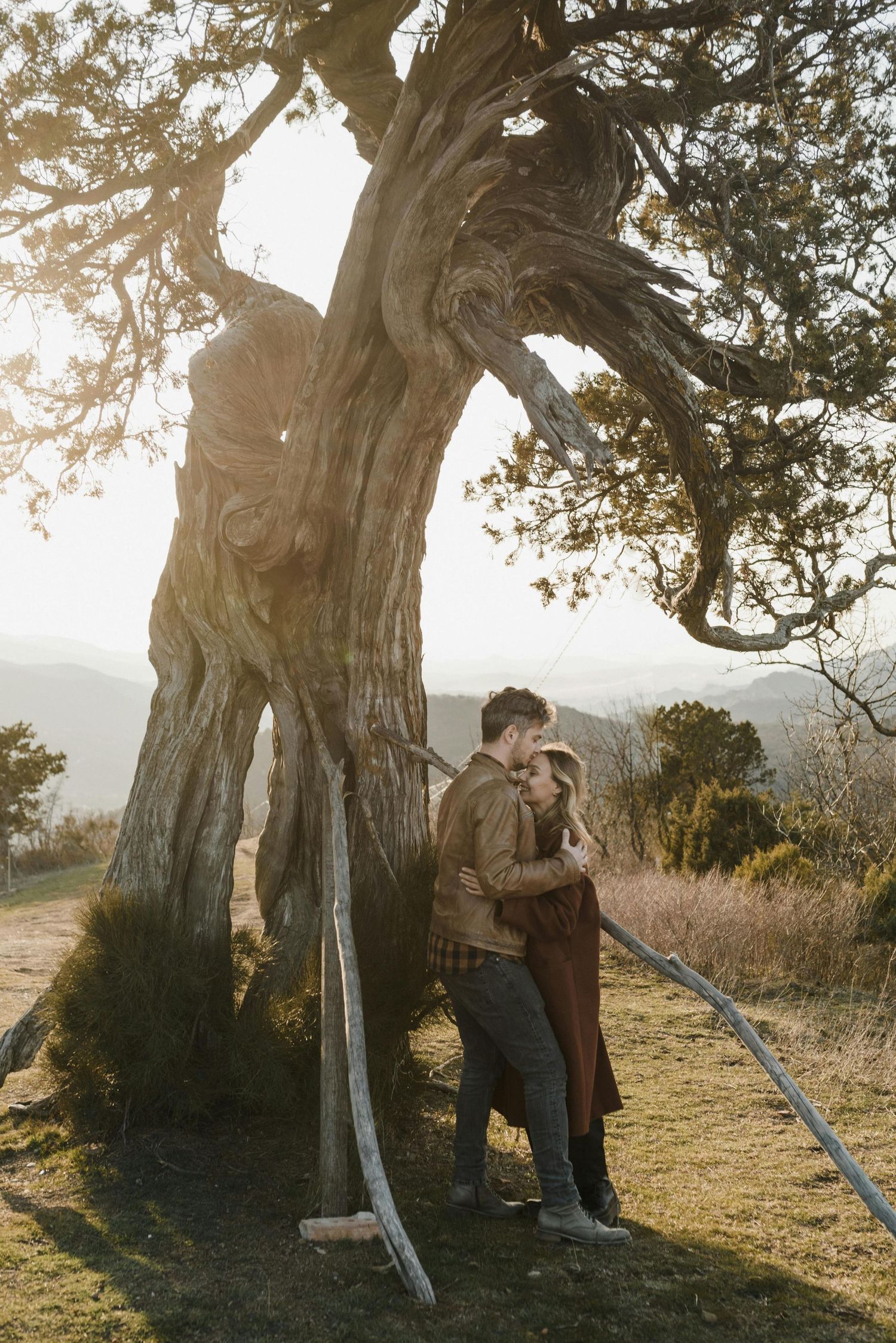 Jerome hillside proposal, couple embracing, red-hatted woman, photographed by Arizona’s leading engagement photographer.