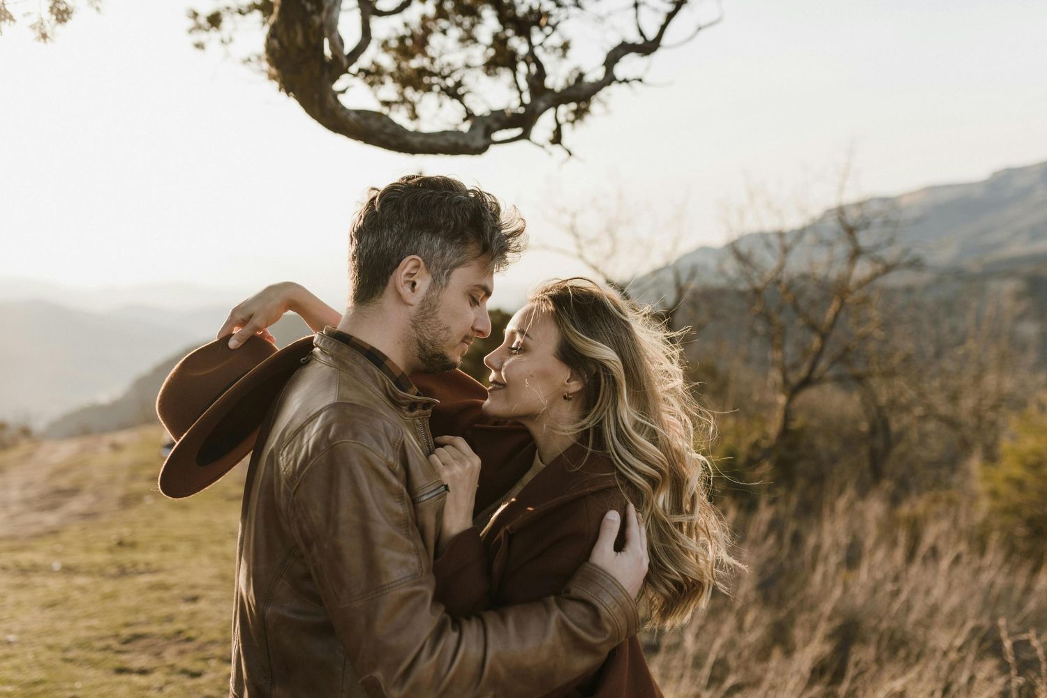 Romantic mountain ridge, couple in love, red-hatted woman, surprise proposal, captured by top engagement photographer Arizona.