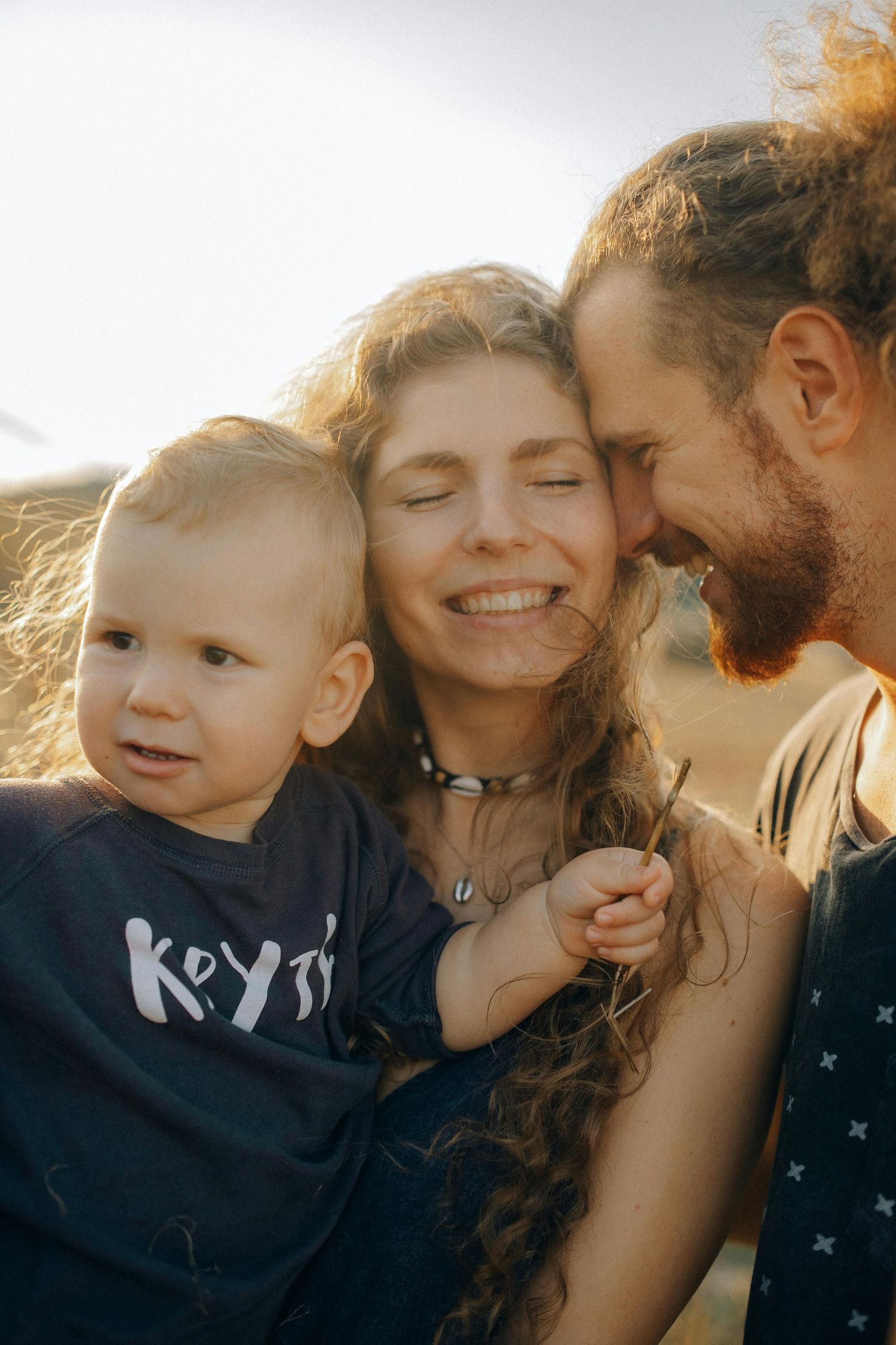 An intimate family portrait captured in golden sunlight showing genuine happiness and connection. Peoria Vistancia