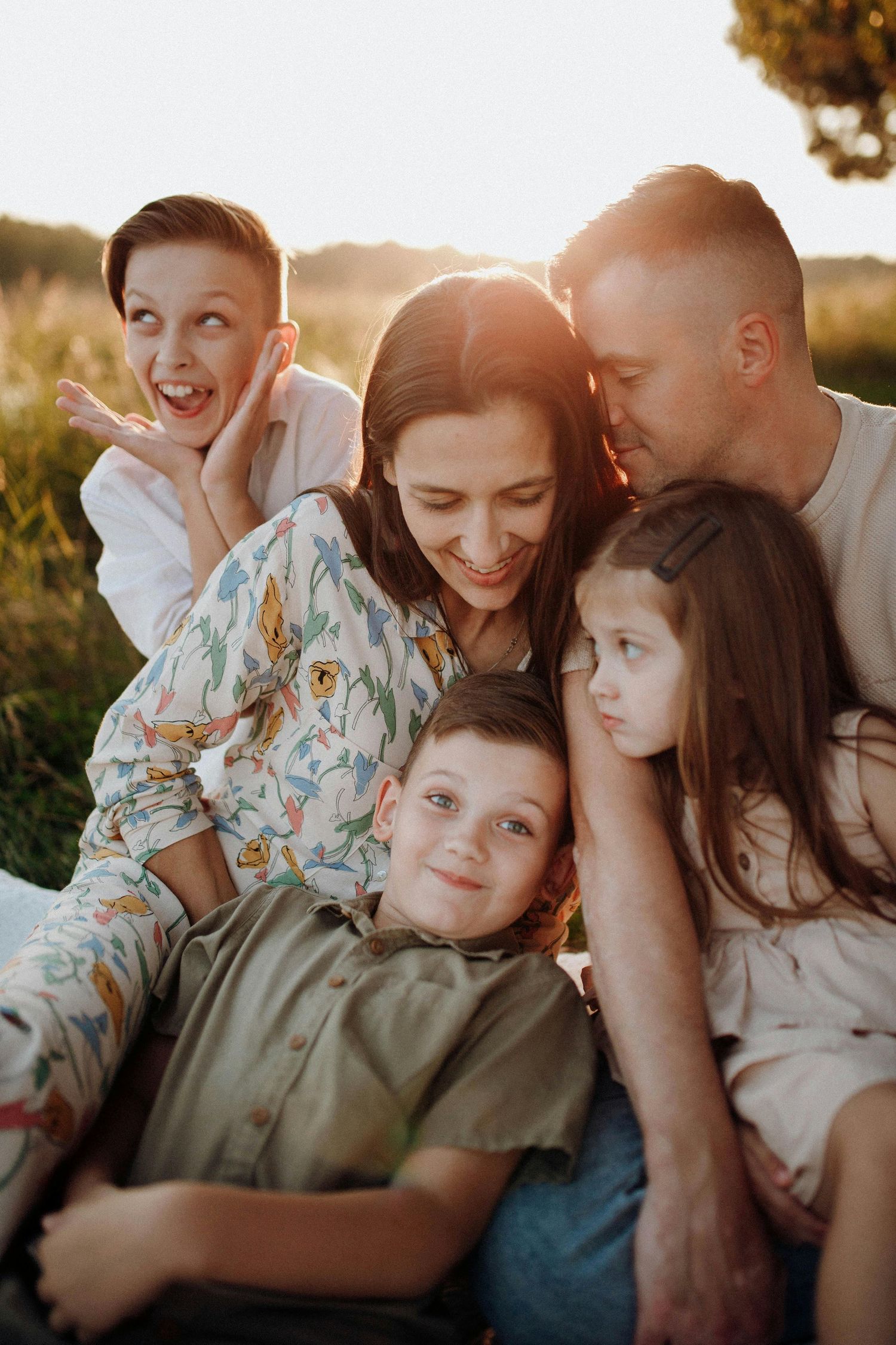 A family shares tender moments together while sitting outdoors during golden hour sunset. Anthem Arizona.