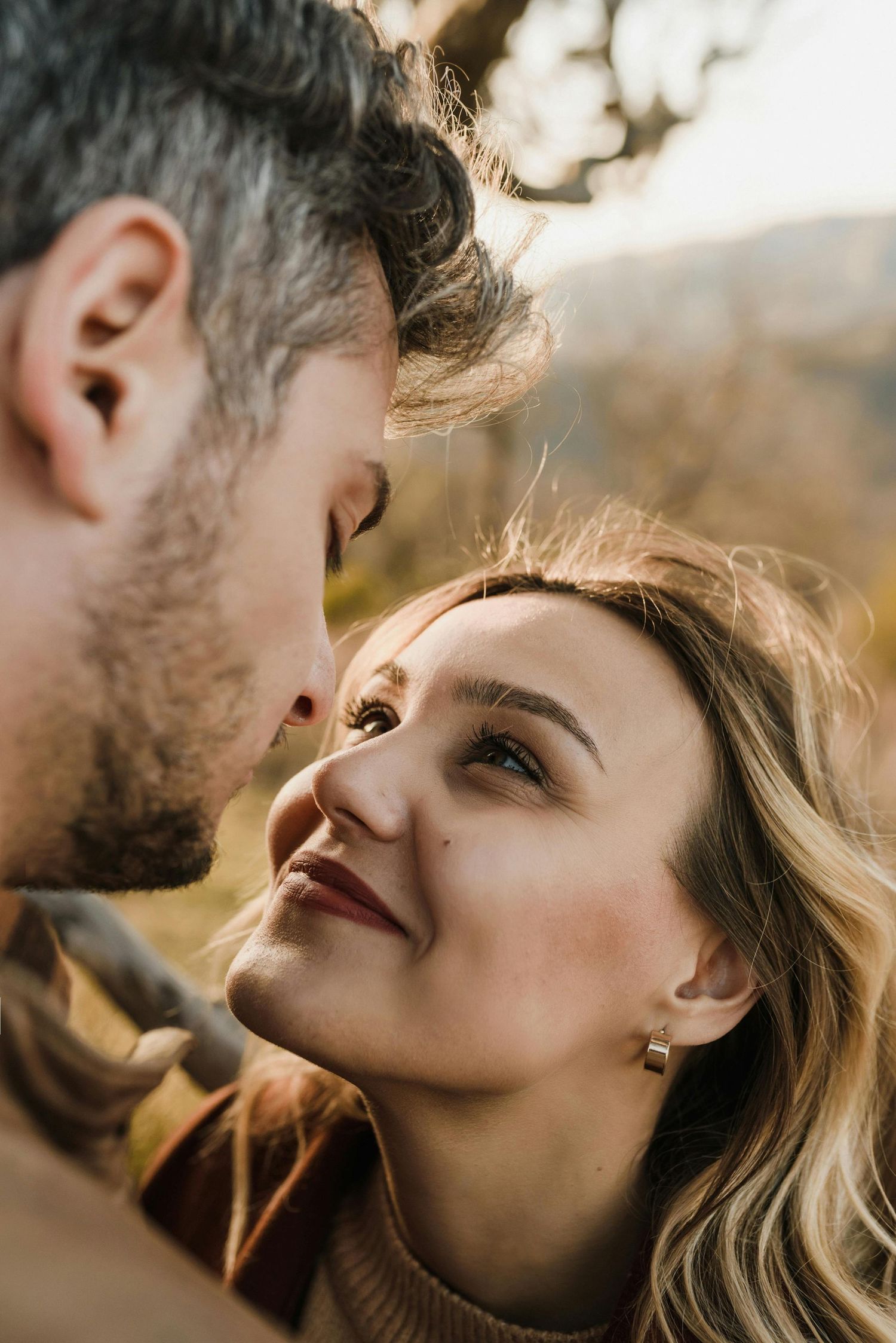 Red-hatted woman smiles, Sedona hills engagement, intimate couple, photographed by premier engagement photographer.