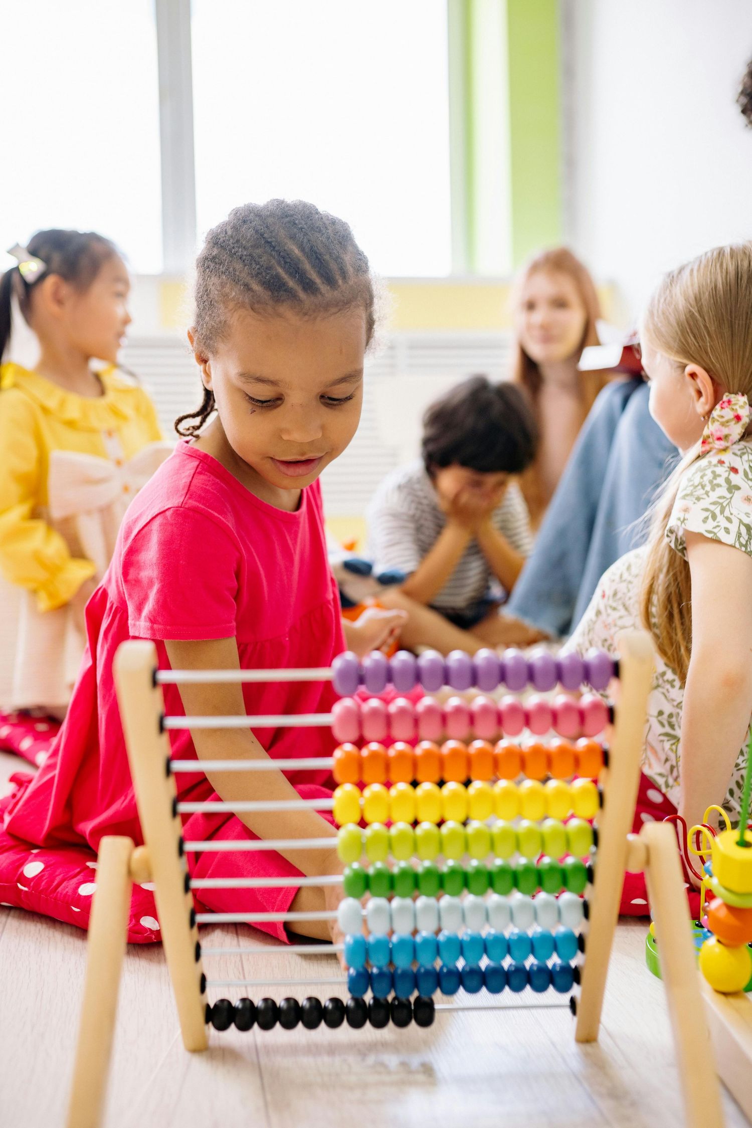 Queen Creek  Arizona Daycare Photography Students using a colorful abacus for counting and math activities.