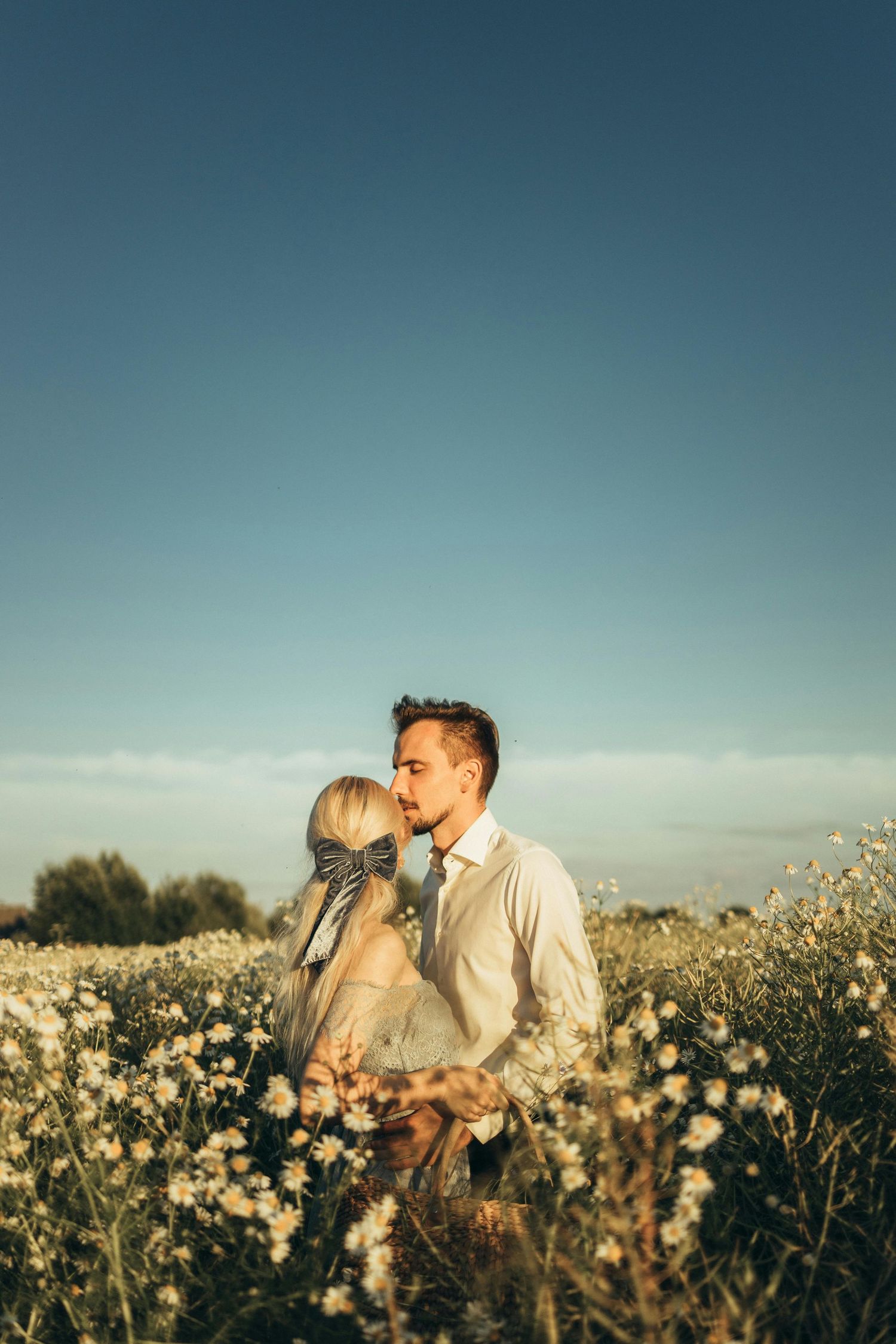 Romantic couple embracing in meadow, captured with warm, intimate, natural light Arizona portrait photography