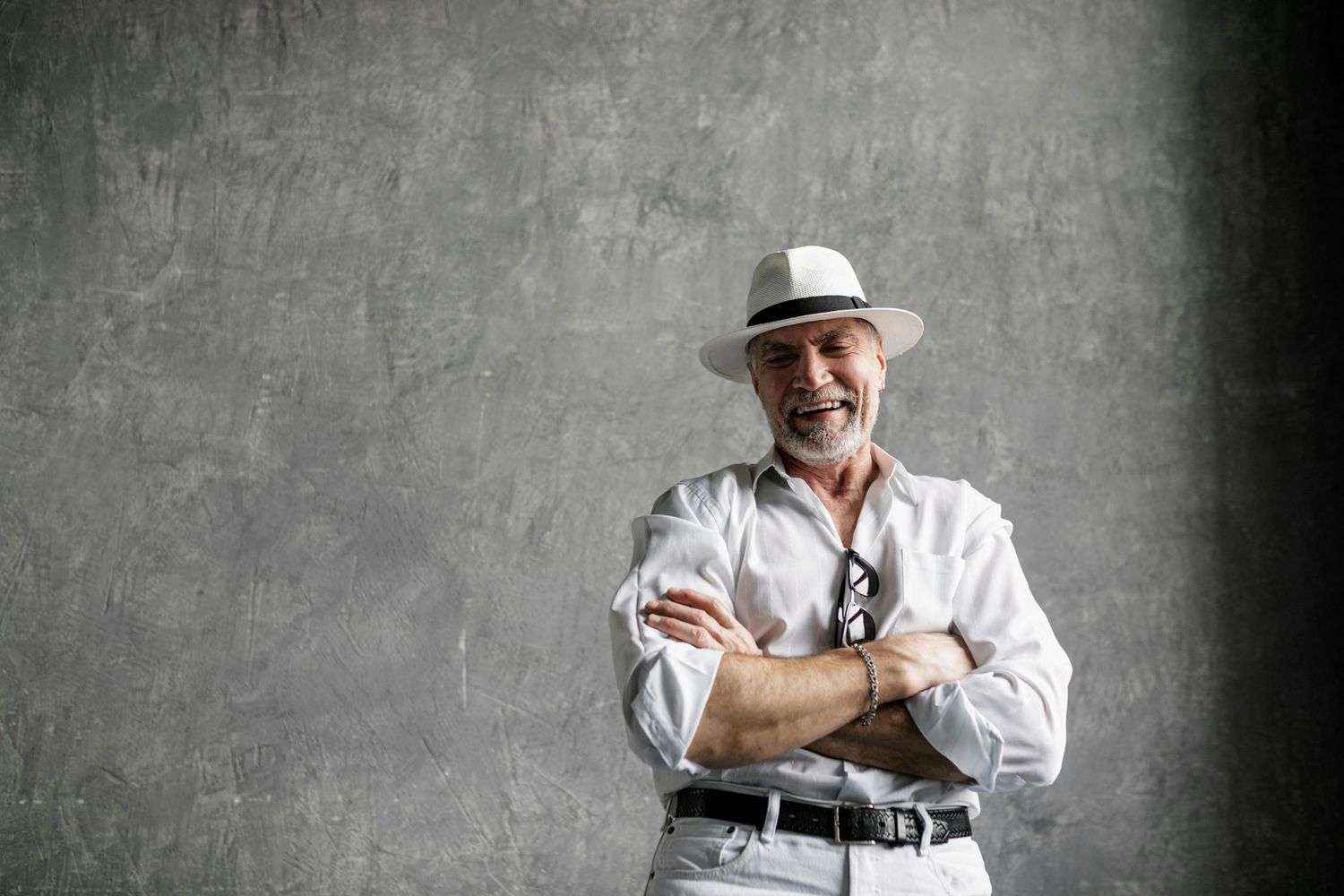 Paradise Valley Arizona Seniors Photography. Stylish figure in all white attire and fedora hat poses expressively against grey backdrop.