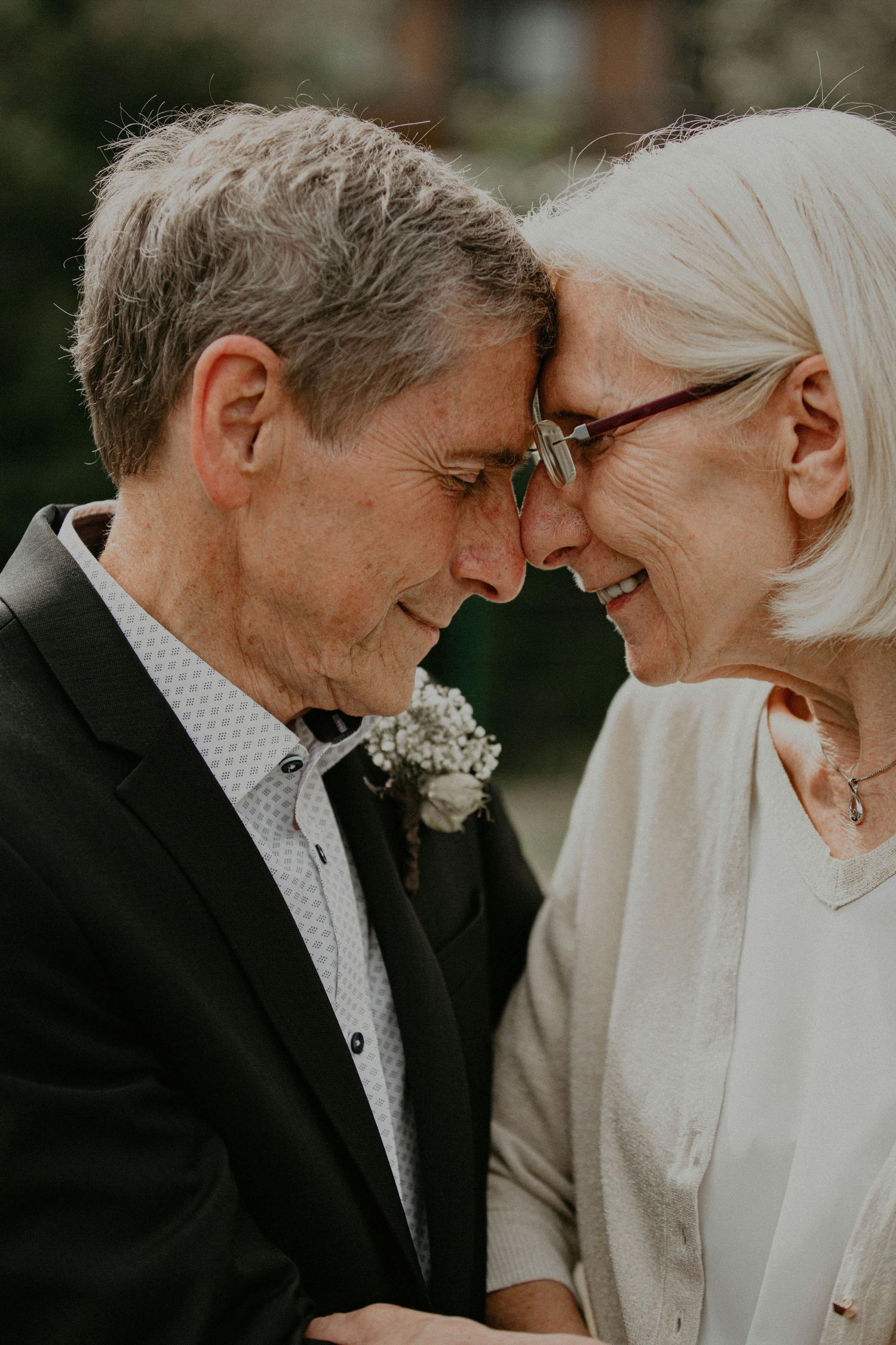 Intimate close-up portrait of an elderly couple sharing a tender moment outdoors.