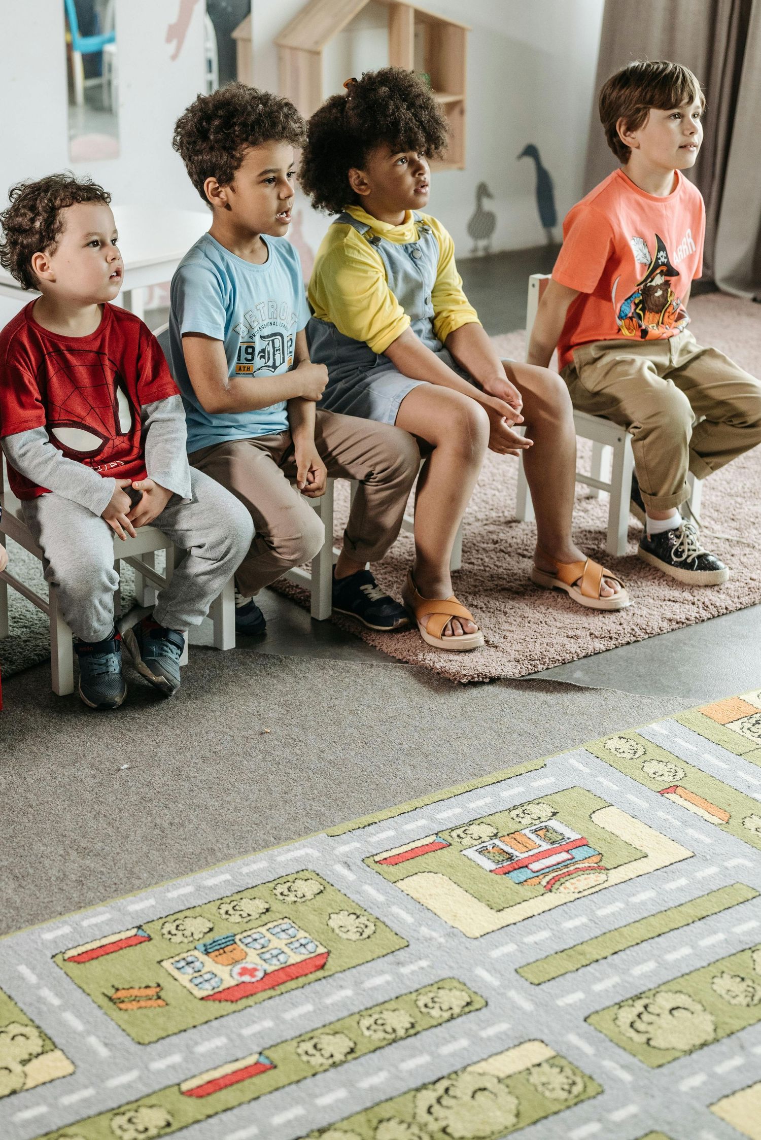 Scottsdale Arizona Photography Children sitting in row on carpet beside colorful floor mat.