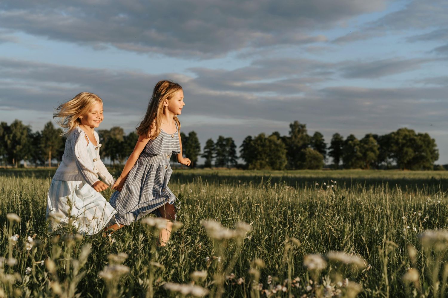 Children's outdoor photography Flagstaff Arizona,panoramic view of figures standing in a vast field at sunset with dramatic clouds overhead