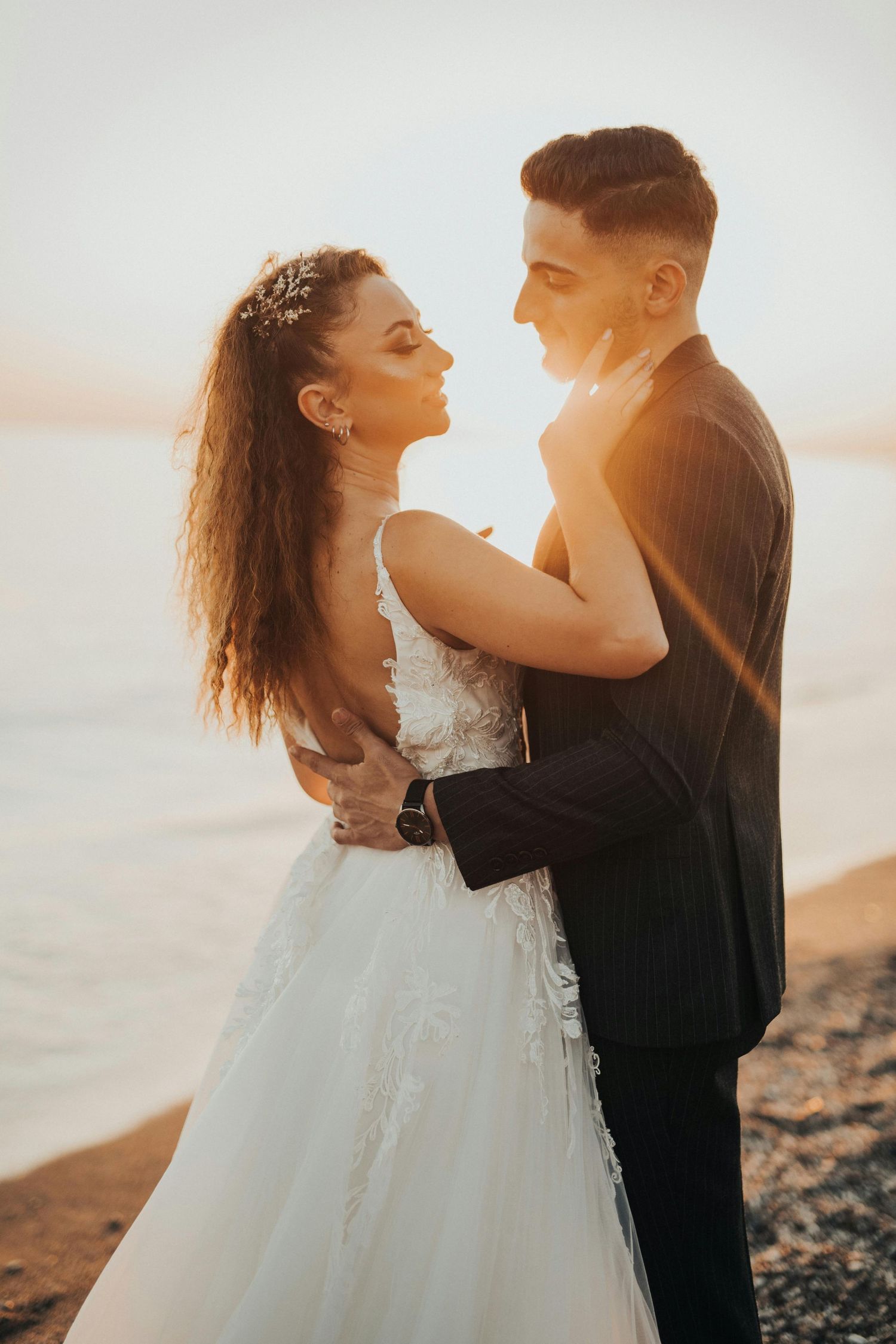 Romantic sunset wedding photoshoot featuring a couple embracing on a beach in warm golden light. Trusted Sedona Photographer.