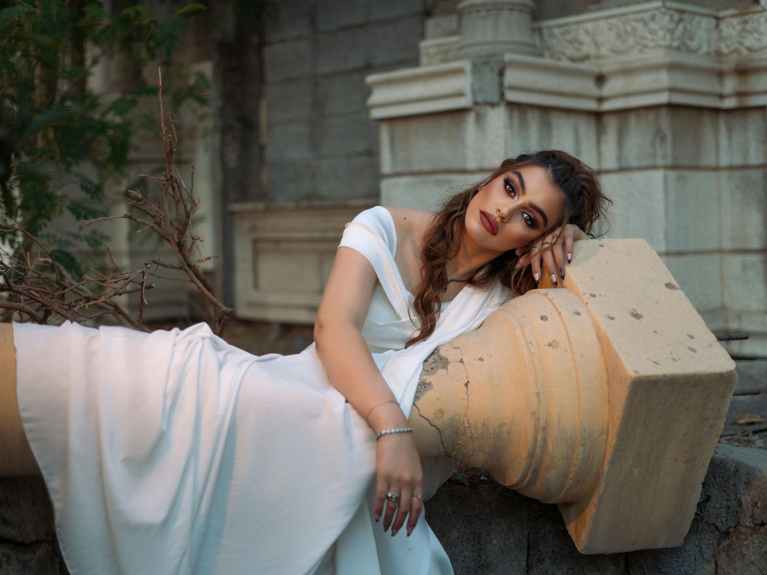A series of artistic bridal portraits featuring a white dress against classical stone architecture. Trusted Flagstaff Photographer.