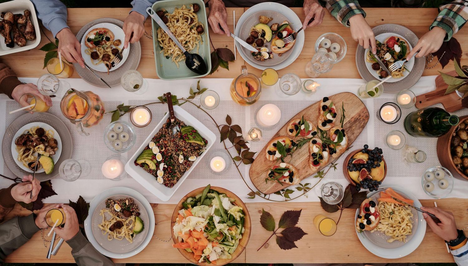 Overhead view of an elegant wedding reception dinner table with multiple place settings and candlelight.