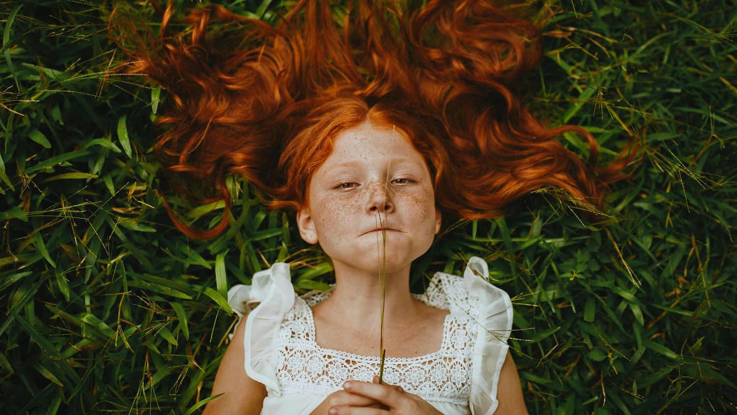 A sequence of six photos shows vibrant red hair splayed out on green grass in different artistic arrangements.