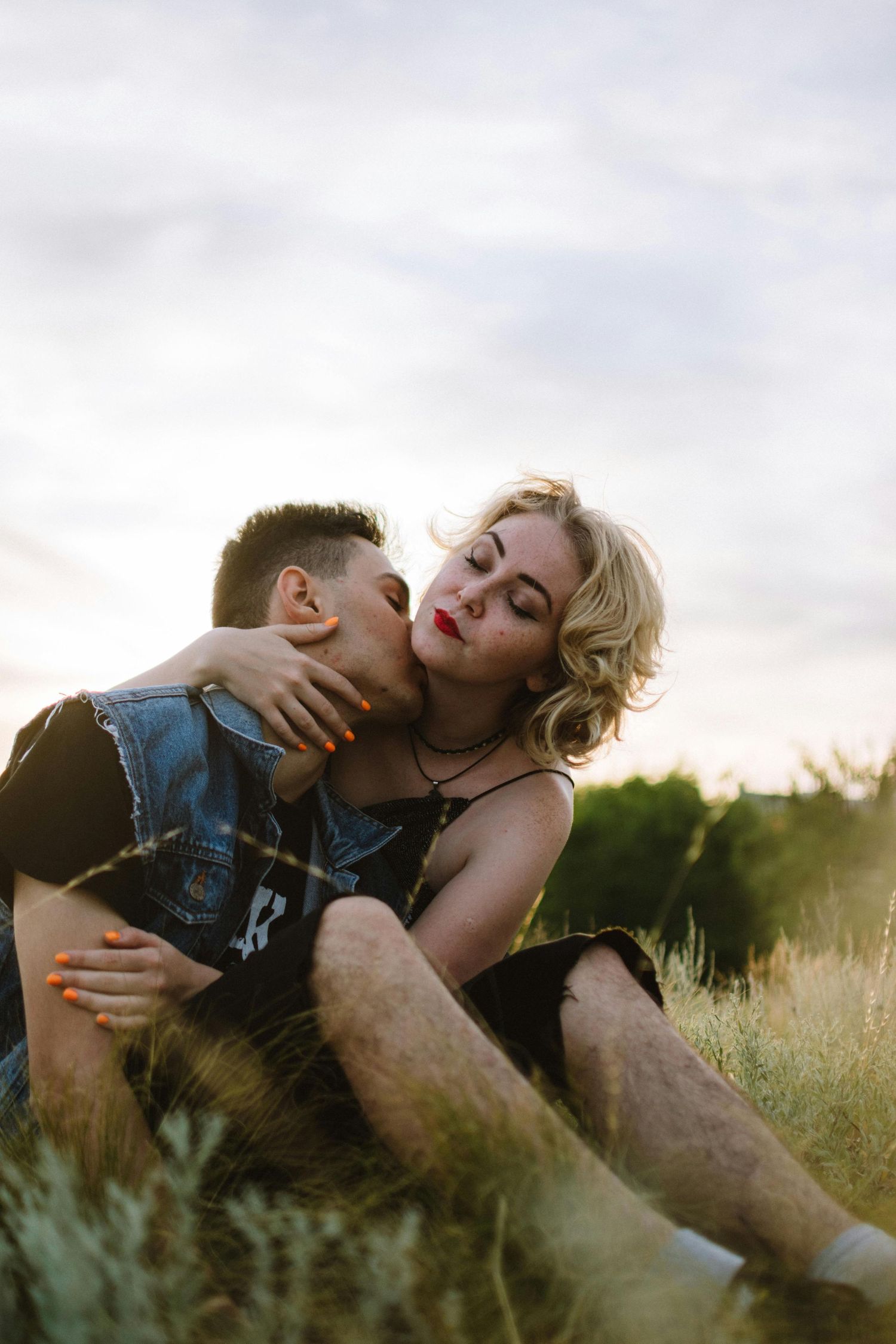 A romantic couple embraces in a sunlit meadow during golden hour, captured in a series of intimate poses. Top Photographer Scottsdale.