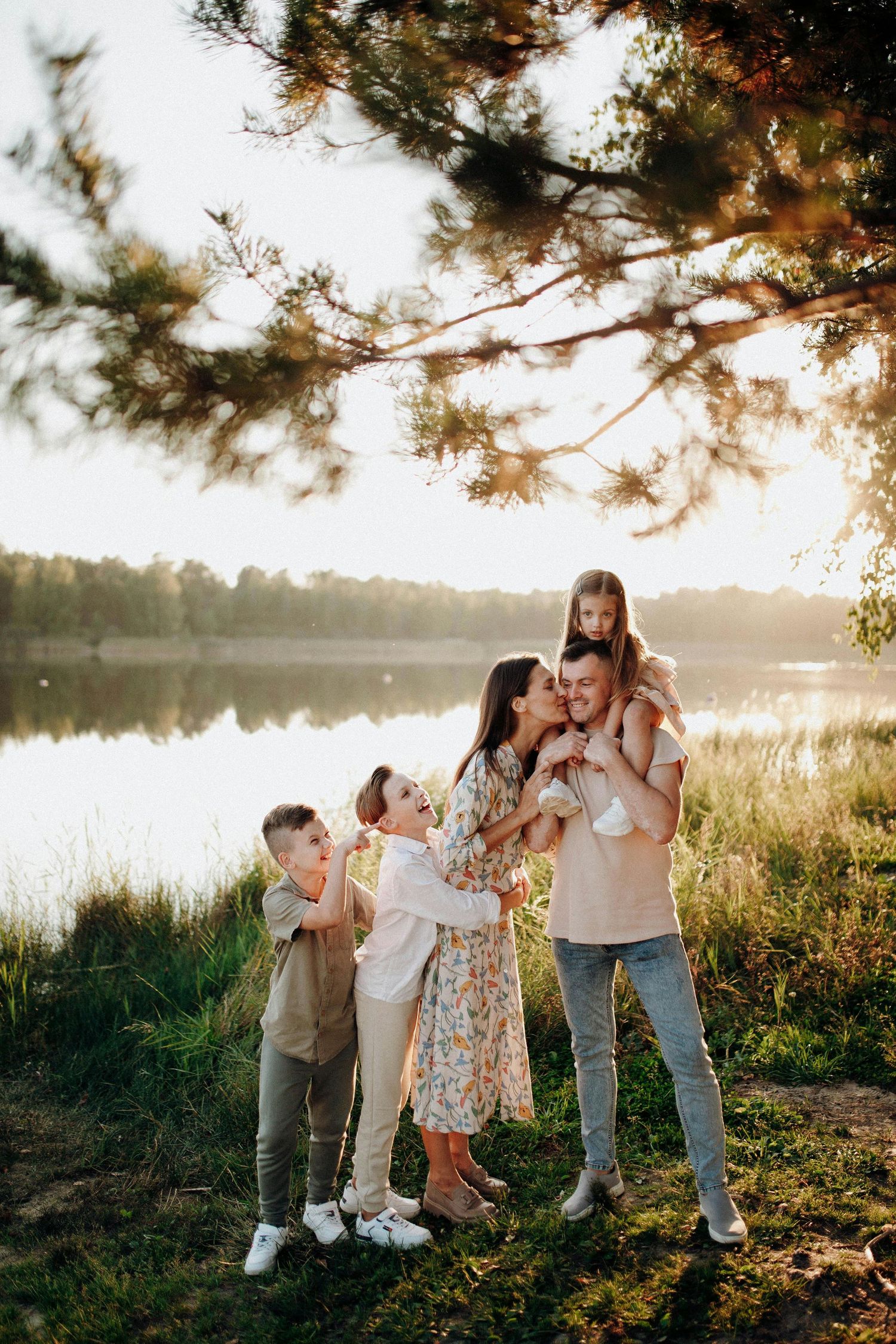 Prescott Arizona, mountaintop Family photography, Family enjoying a playful moment together outdoors by a lake during golden hour.