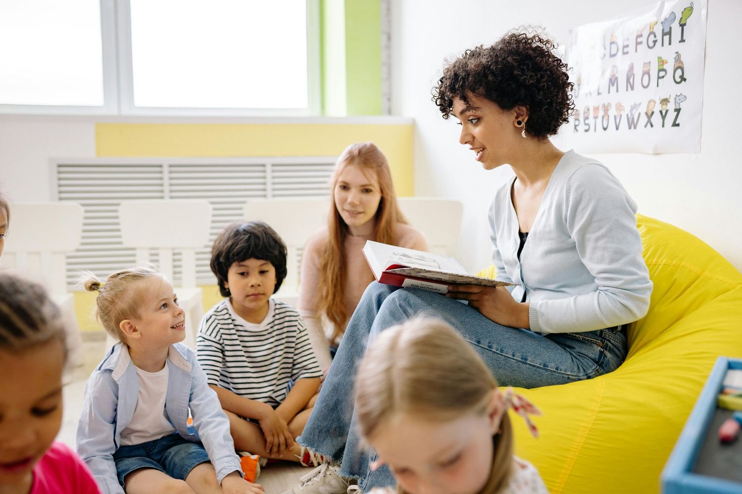 Queen Creek  Arizona Daycare Photography Children engaged in an educational activity with an instructor in a bright classroom setting.