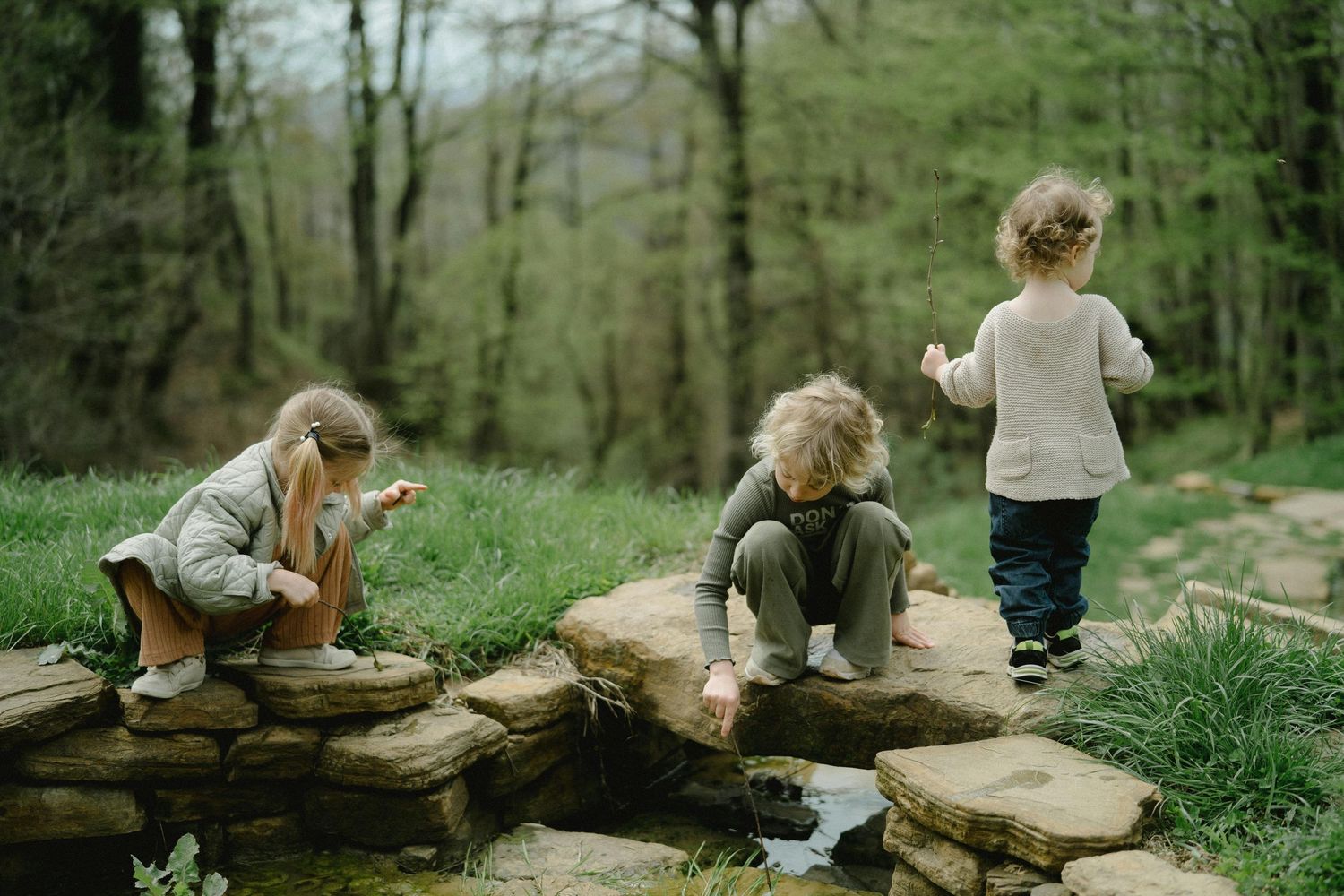 San Tan Valley Arizona Family Photography Children exploring a natural log formation in a wooded area.