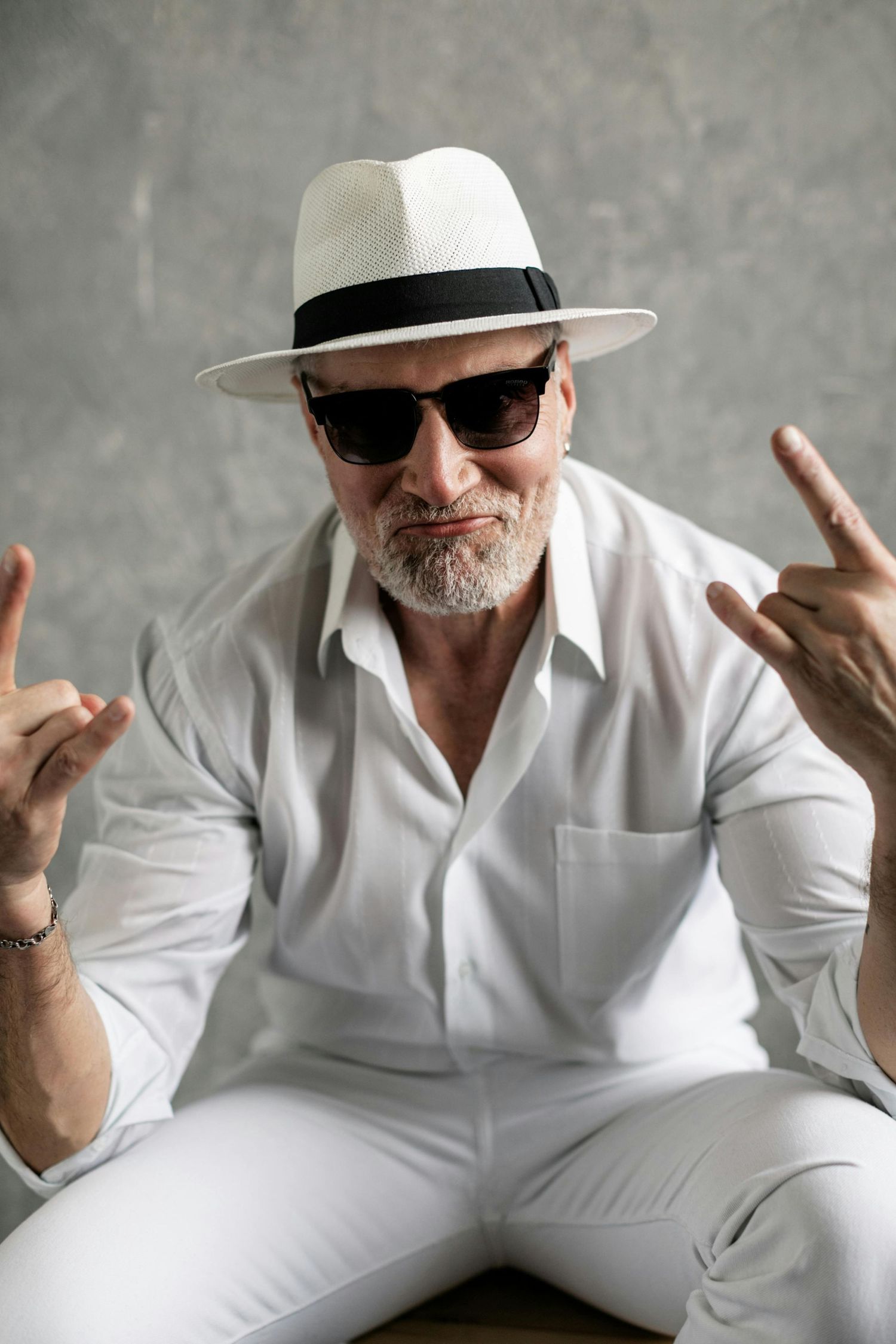 Paradise Valley Arizona Seniors Photography. Expressive poses in white outfit with sunglasses and hat against grey background.