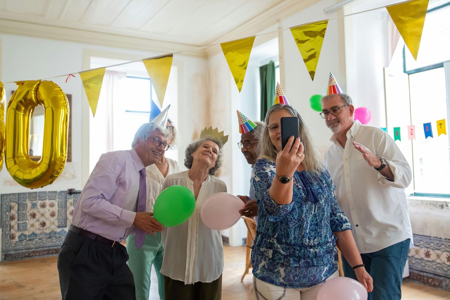 Luxury Photographer, Biltmore Arizona. Celebration in a bright room decorated with yellow pennant banners and balloons.