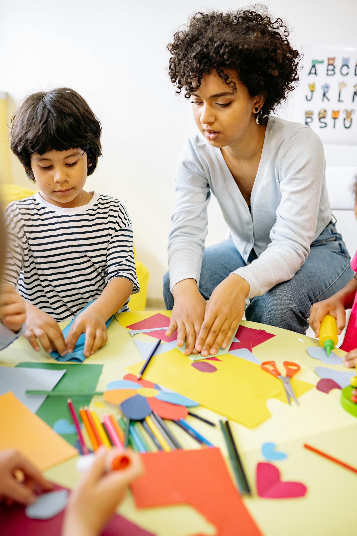 Queen Creek  Arizona Daycare Photography Students working on colorful paper craft activities at a table with educational materials.