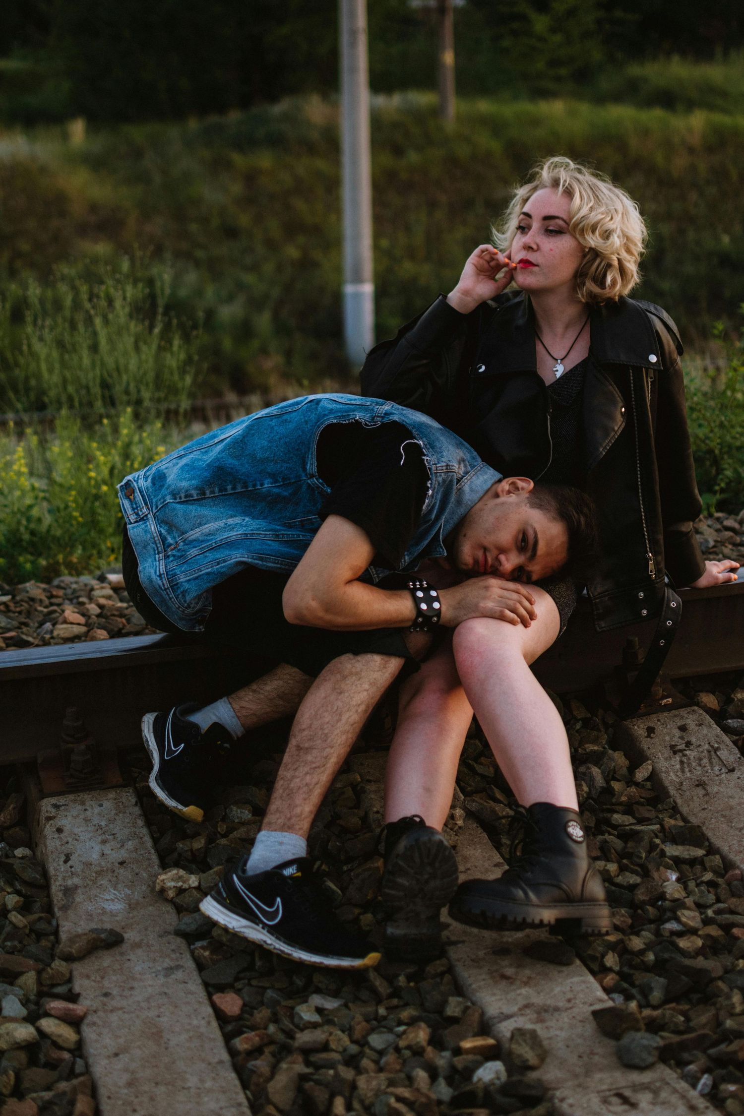 Two people in casual clothing sit close together on concrete steps at dusk. Top Photographer Scottsdale.
