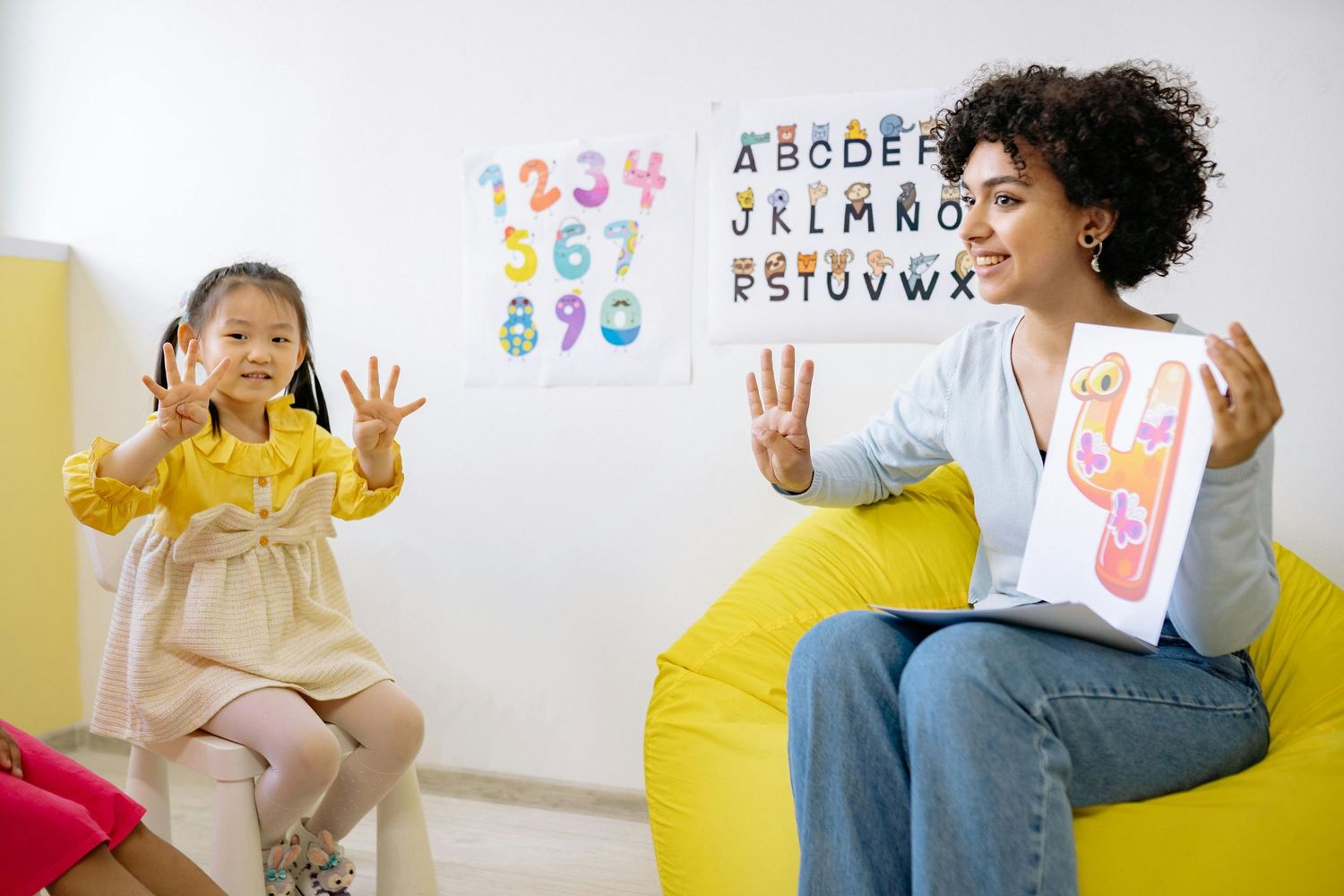 Queen Creek  Arizona Daycare Photography Educational setting with alphabet letters and numbers displayed on white wall.