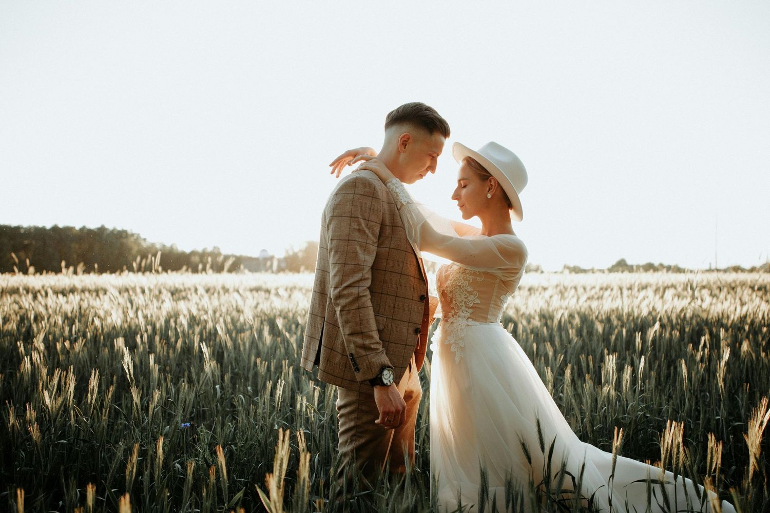 A couple shares a romantic moment in a golden wheat field at sunset in northern arizona