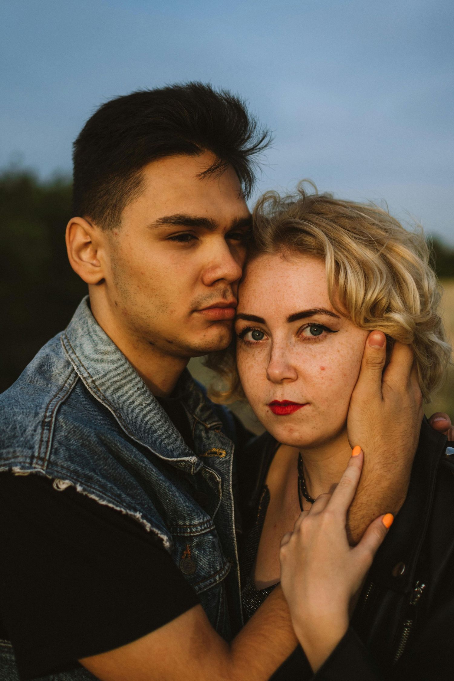 A romantic couple shares intimate moments in a series of outdoor portraits at sunset wearing denim and black clothing. Top Photographer AZ