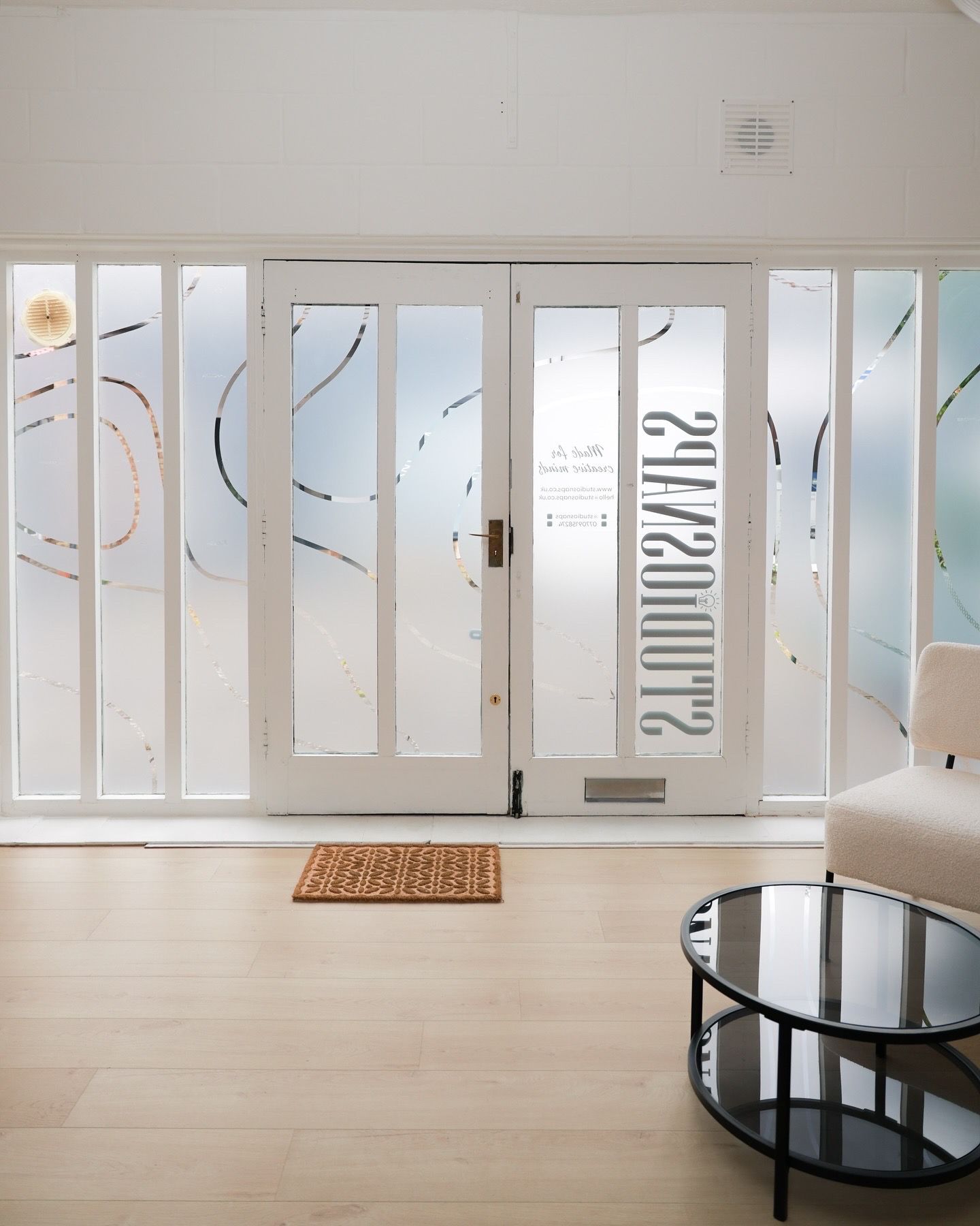 Modern interior space with white walls and large windows creating natural light.