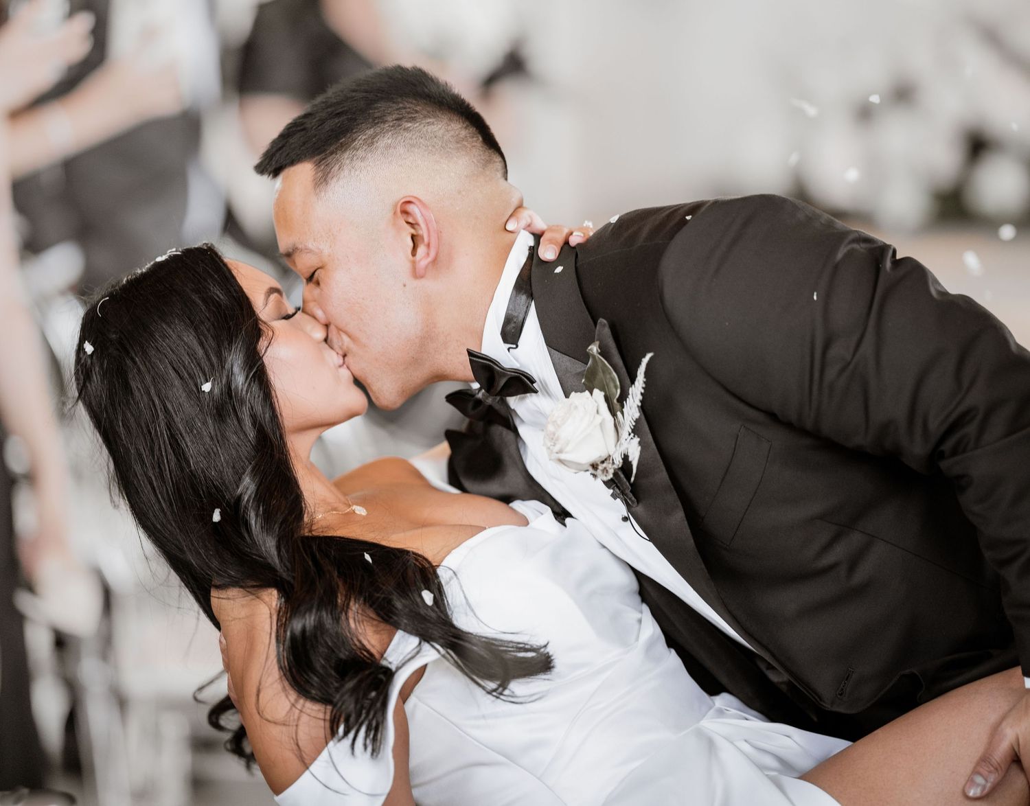 Intimate wedding portrait capturing a dip kiss moment between newlyweds in formal attire.