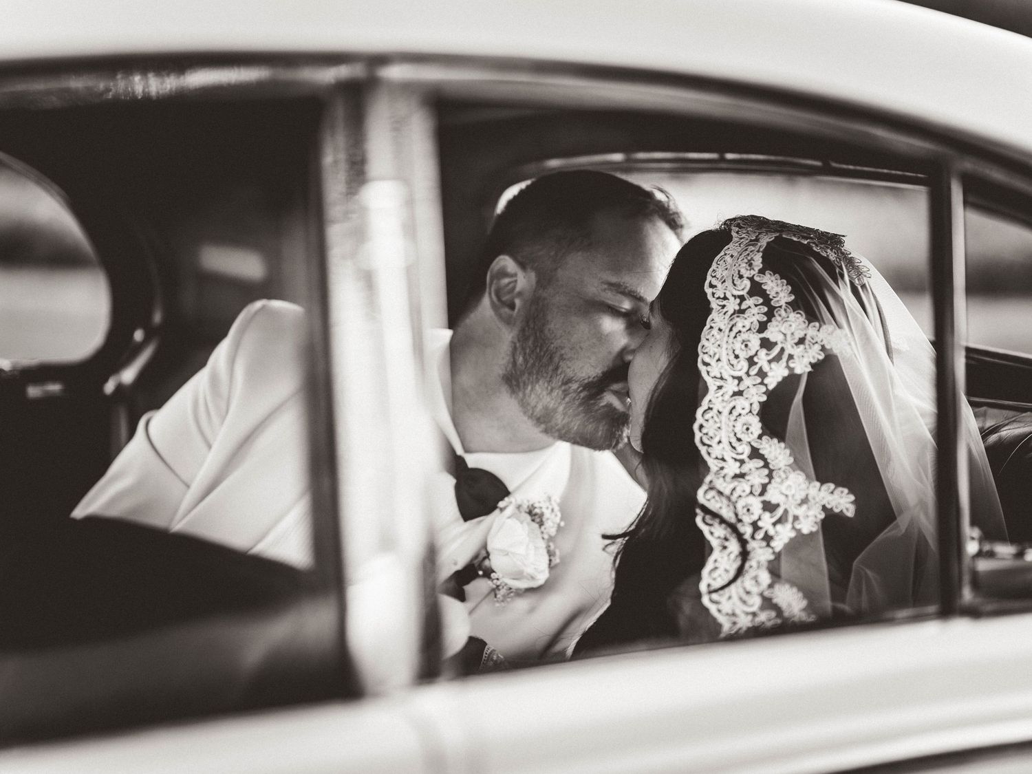 Vintage car wedding portraits in black and white with classic styling.