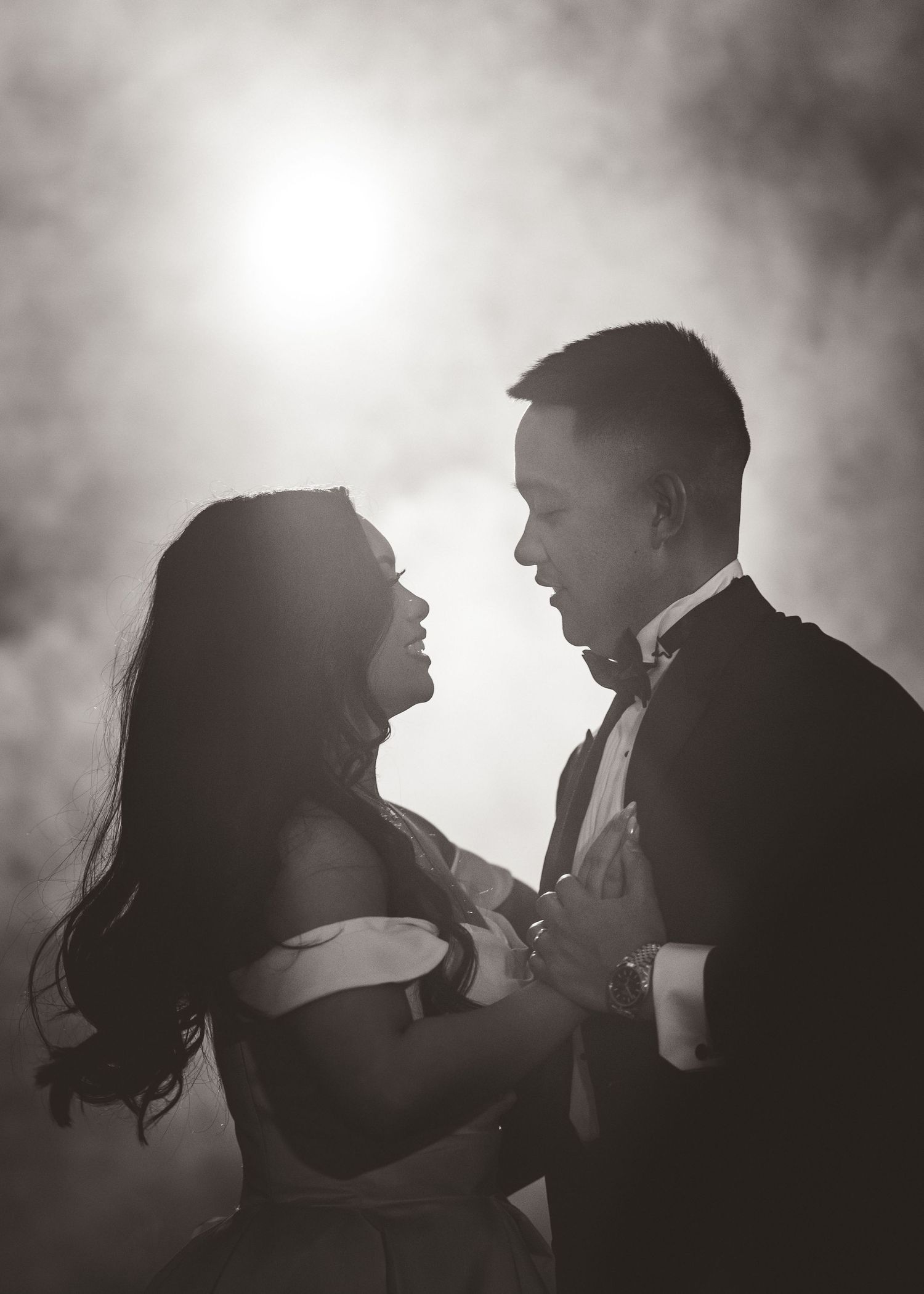 Romantic silhouette of a couple gazing at each other in dramatic lighting during their wedding photoshoot.