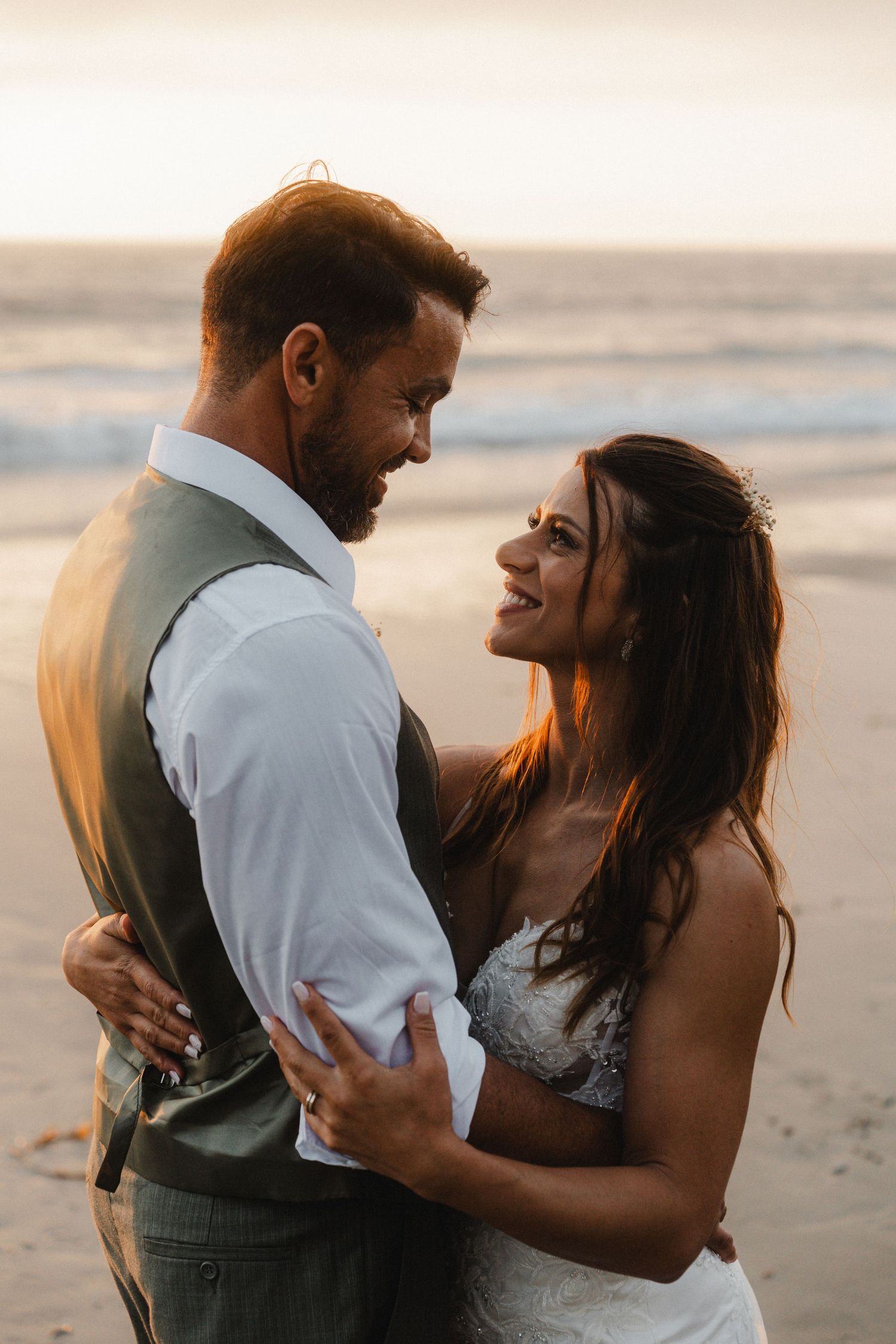 Sunset beach wedding photos capturing joyful moments between newlyweds.