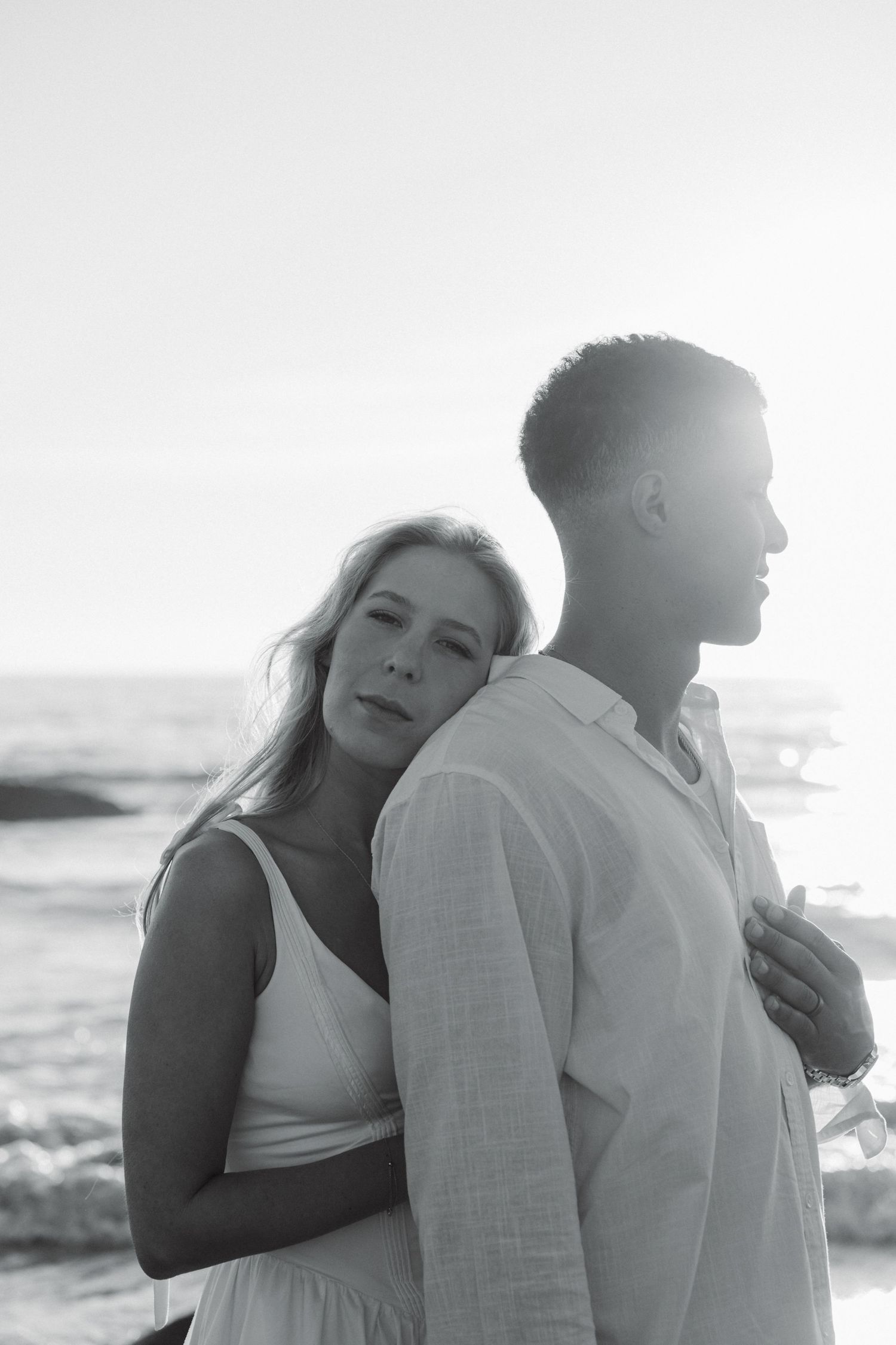 Black and white photo sequence showing a couple embracing on a beach at sunset.