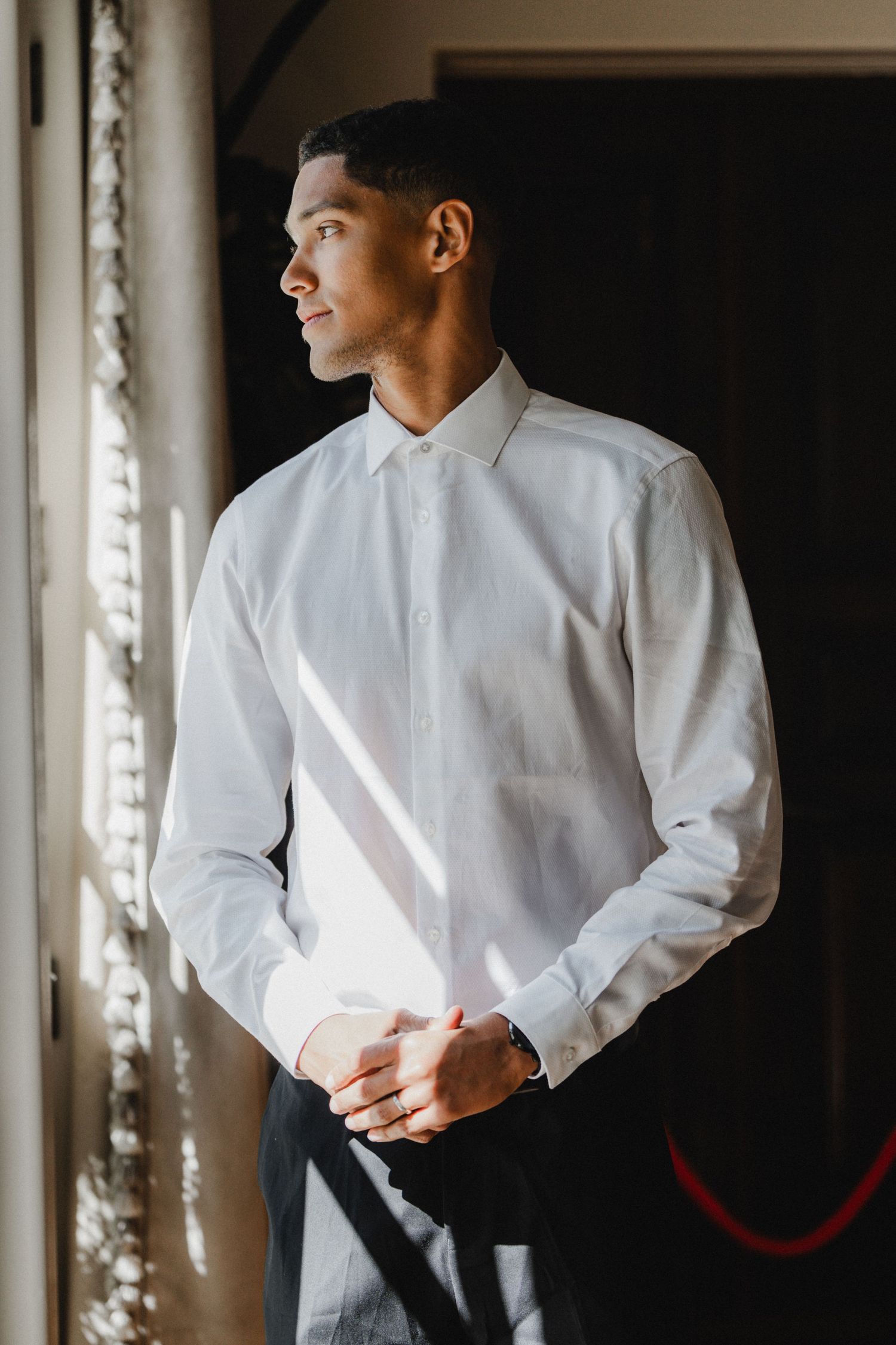 A series of artistic shots showing a person in a crisp white dress shirt against a dark background.