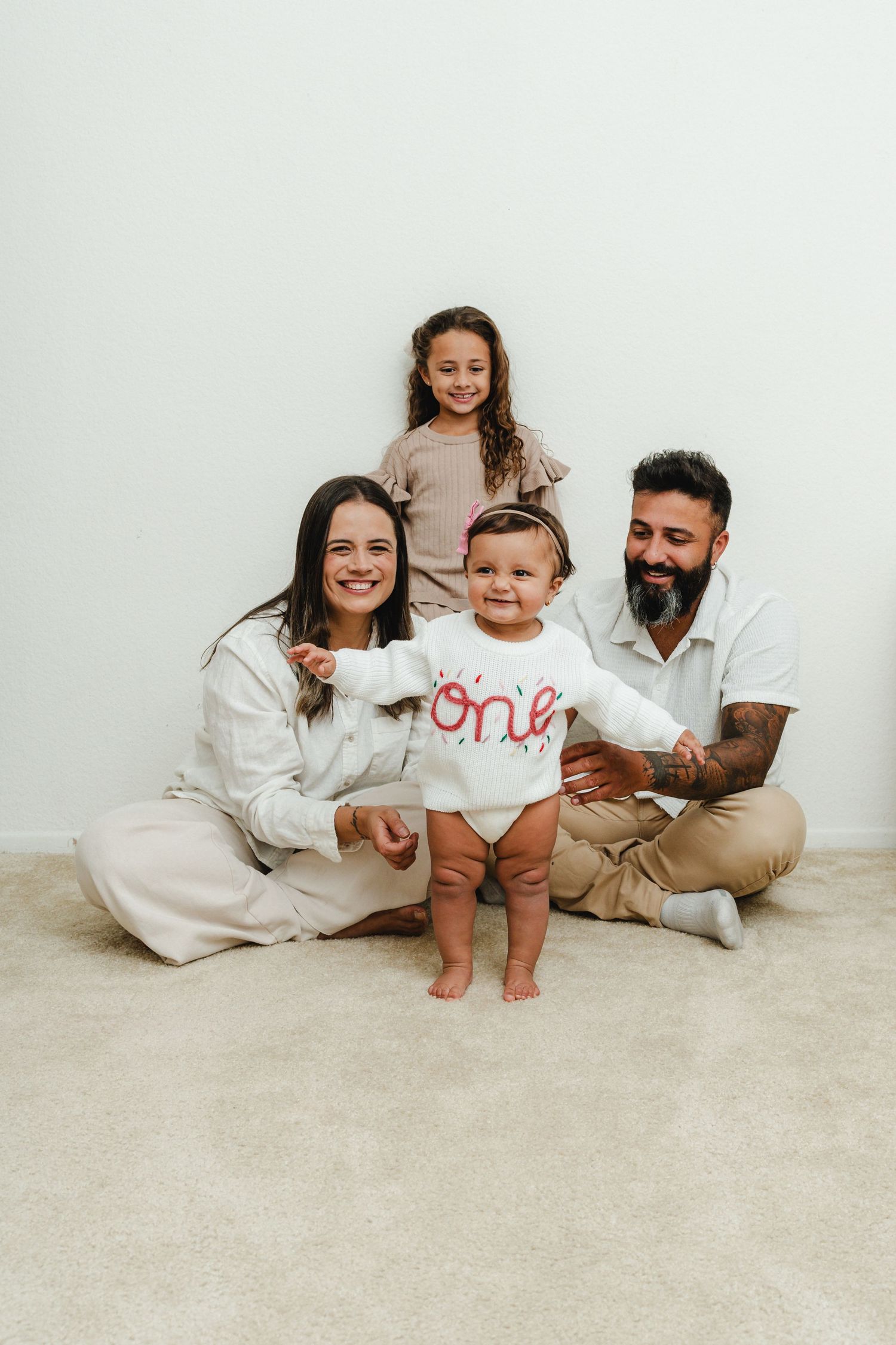 A family lounges together on the floor during a casual portrait session.