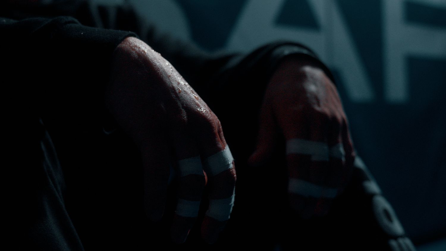 Dimly lit urban scene with dark silhouettes against blue-tinted background.