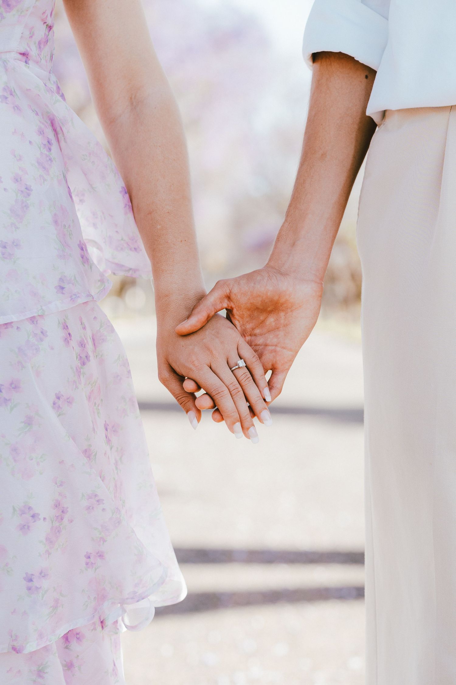 Close-up of hands showing off a new engagement ring.