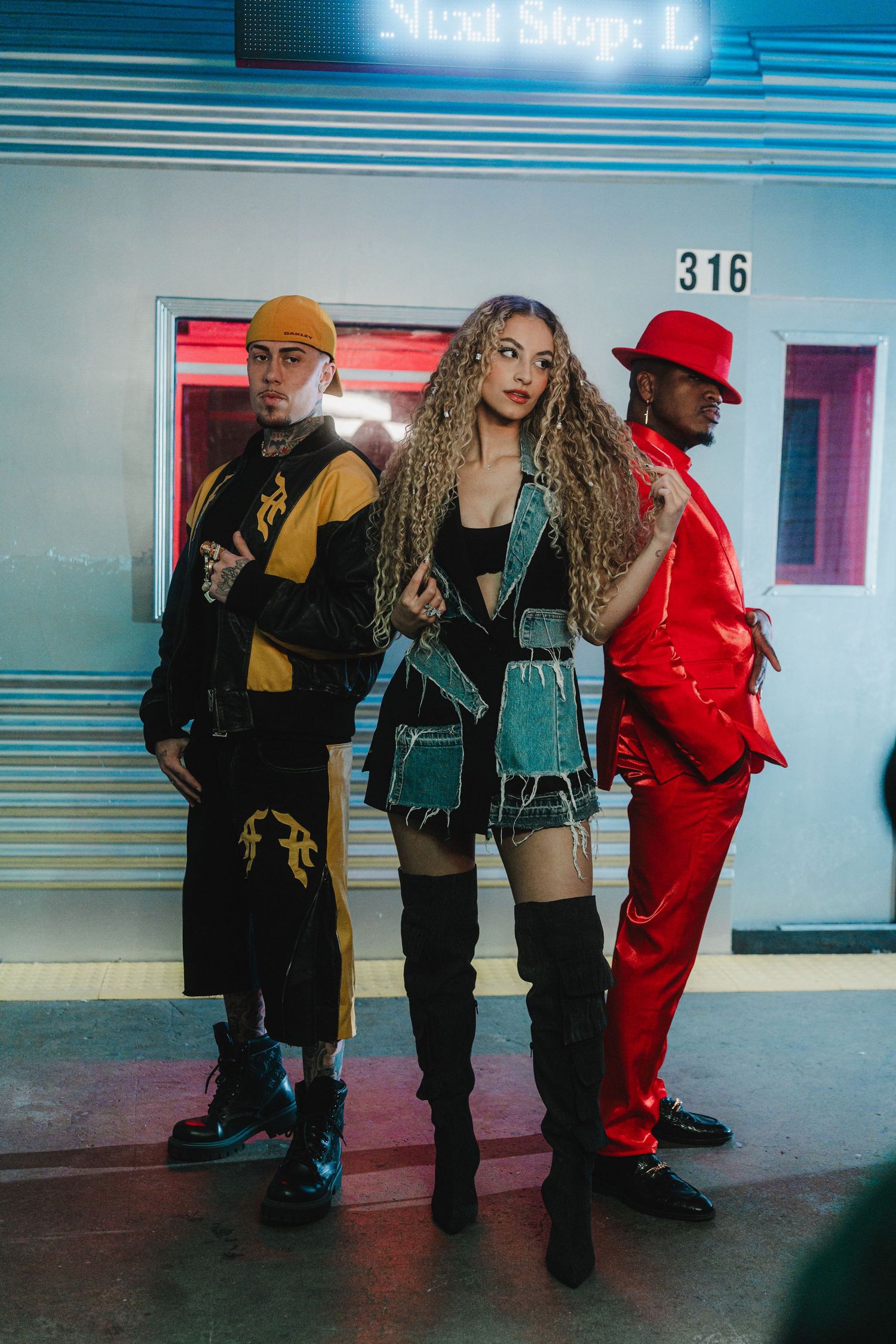 Three people in stylish outfits posing in front of retro diner backdrop.