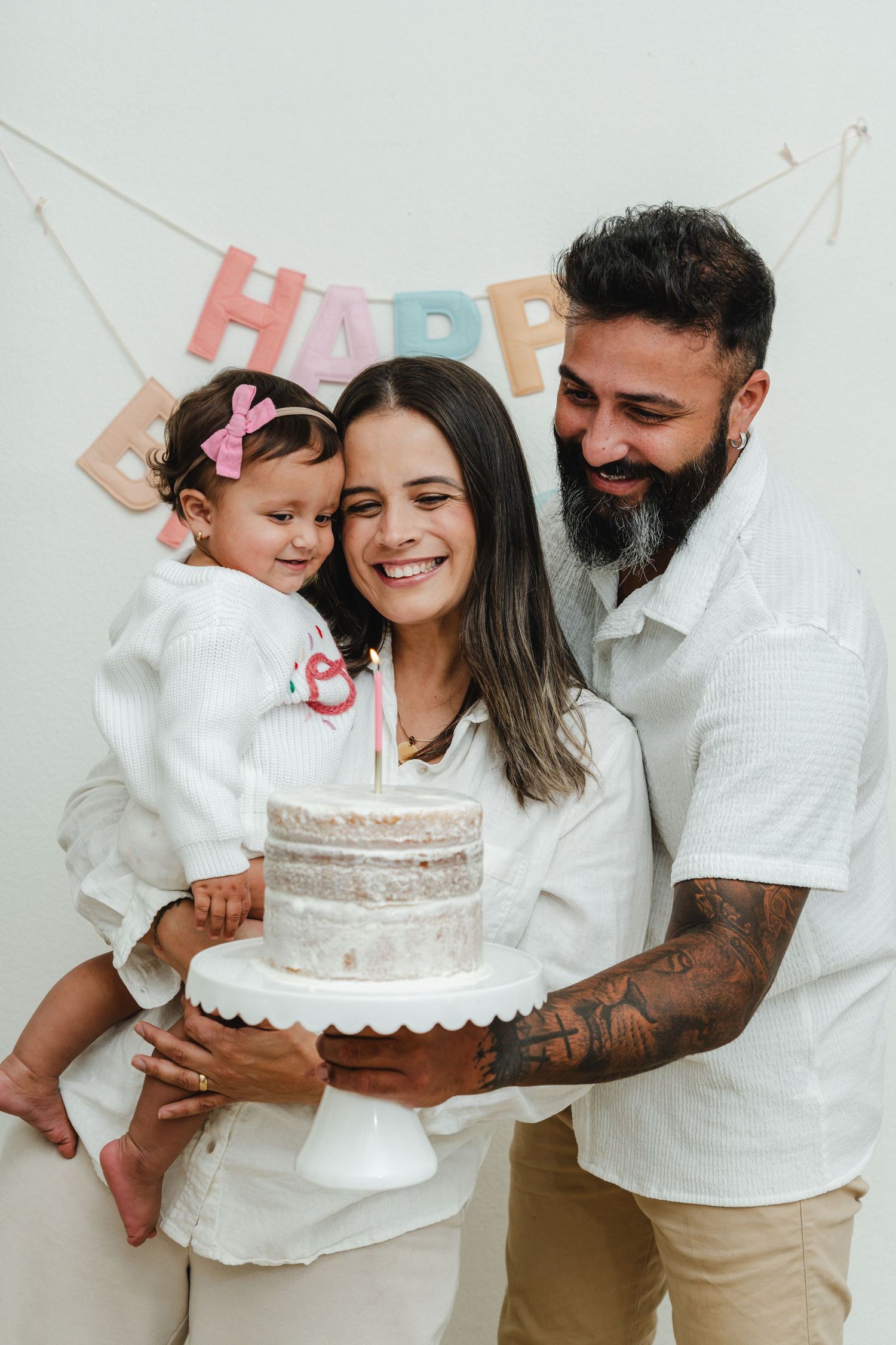 A family shares smiles and laughter while celebrating with a birthday cake.