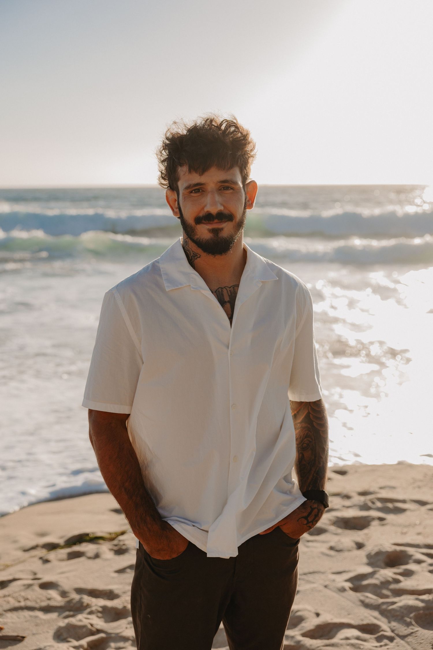 Four sequential photos showing someone in white attire posing on a sunny beach with ocean waves in the background.